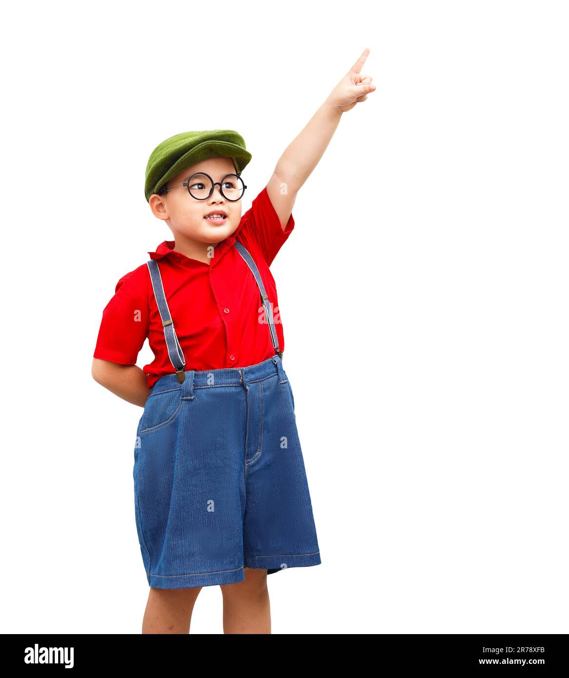 Ein fröhliches Kind trägt ein rotes Hemd, einen grünen Baileys Hut und eine Brille. Zeig mit dem Finger darüber. Stockfoto