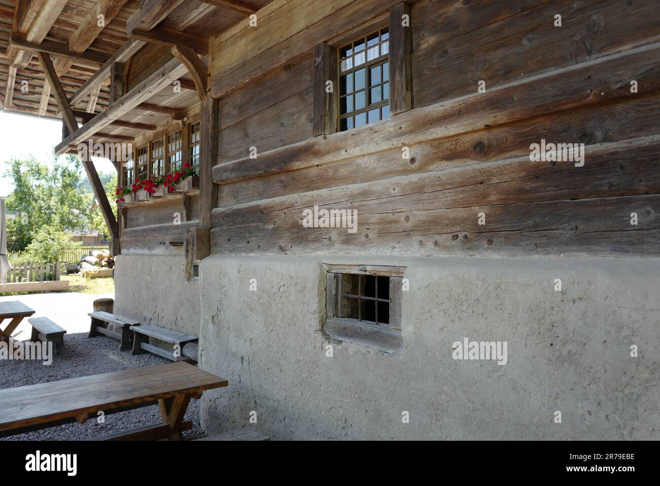 Historisches Holzhaus im Schwarzwald mit roten Blumen in den Fenstern Stockfoto