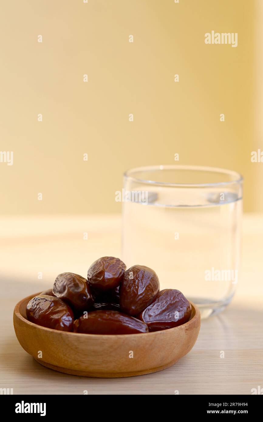 Ramadan iftar Essen, Dattelfrüchte und Glas oder Wasser auf einem Holztisch. Stockfoto