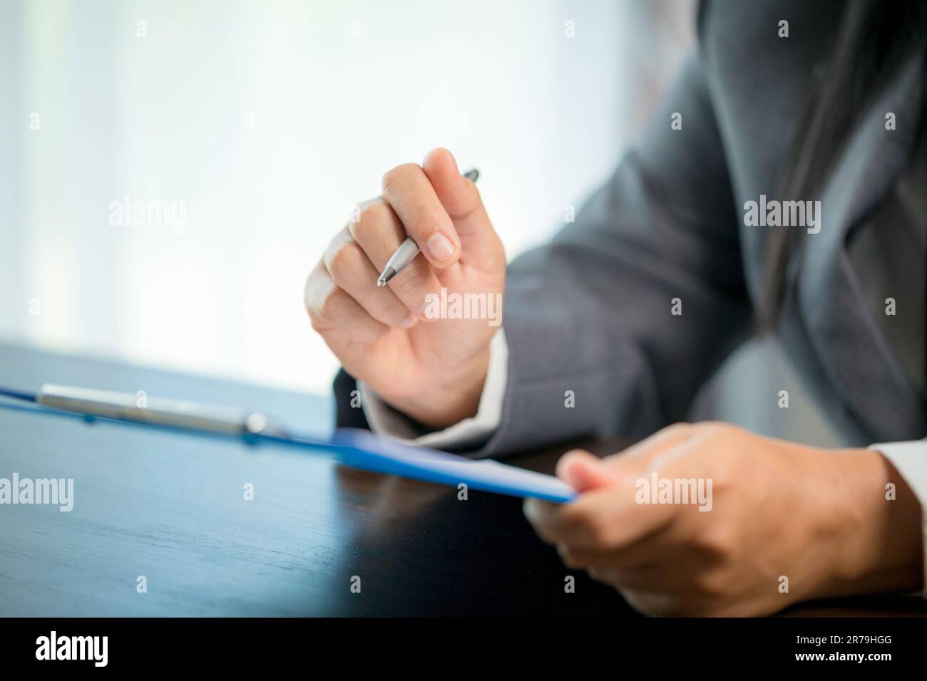 Person für Nahaufnahmen am Arbeitsplatz, professionelle Geschäftsfrau, die am Schreibtisch sitzt, hält eine Unterschrift oder Unterschriftenunterschrift. Angestelltenfrau, die den Vertrag unterzeichnet Stockfoto