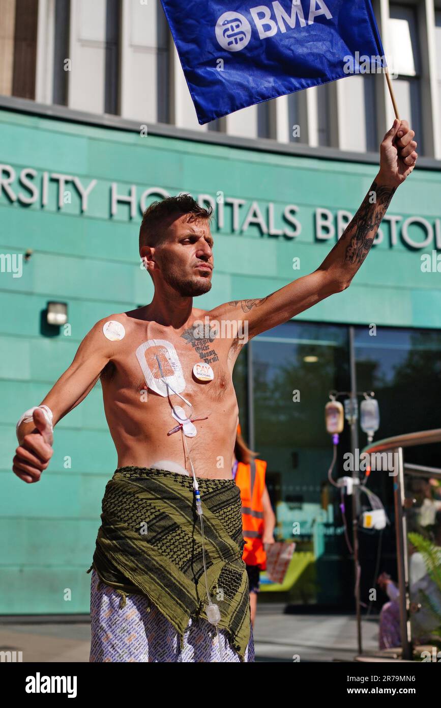 Patient Luke Rovira schließt sich streikenden Juniorärzten der British Medical Association an der Streiklinie vor dem Bristol Royal Infirmary an. Die 72-stündige Unterbrechung läuft von Mittwoch, den 14. Juni, 7am Uhr bis Samstag, den 7am. Juni, um 17 Uhr nacheinander mit der Regierung, die zu viel bezahlt hat. Bilddatum: Mittwoch, 14. Juni 2023. Stockfoto