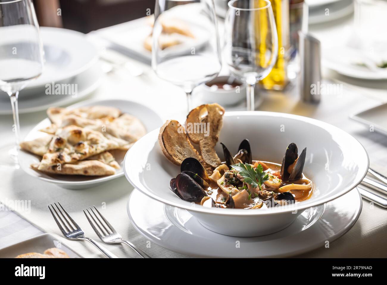 Meeresfrüchte und Fischsuppe werden in einem italienischen Restaurant in elegantem Ambiente serviert. Stockfoto