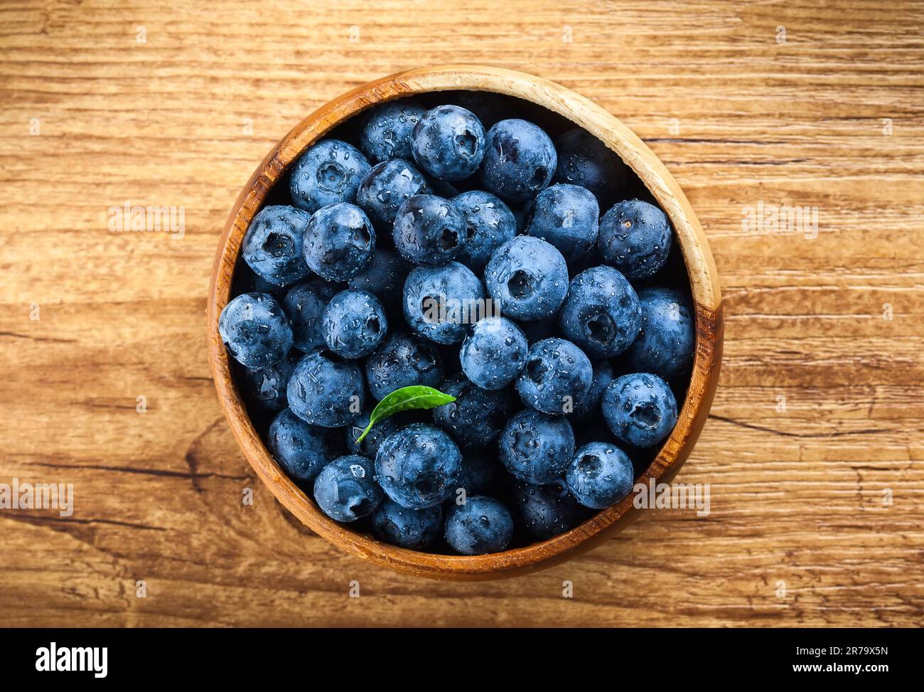 Frische Blaubeere mit Wassertropfen auf Holzhintergrund. Draufsicht. Konzept der gesunden und diätetischen Ernährung Stockfoto