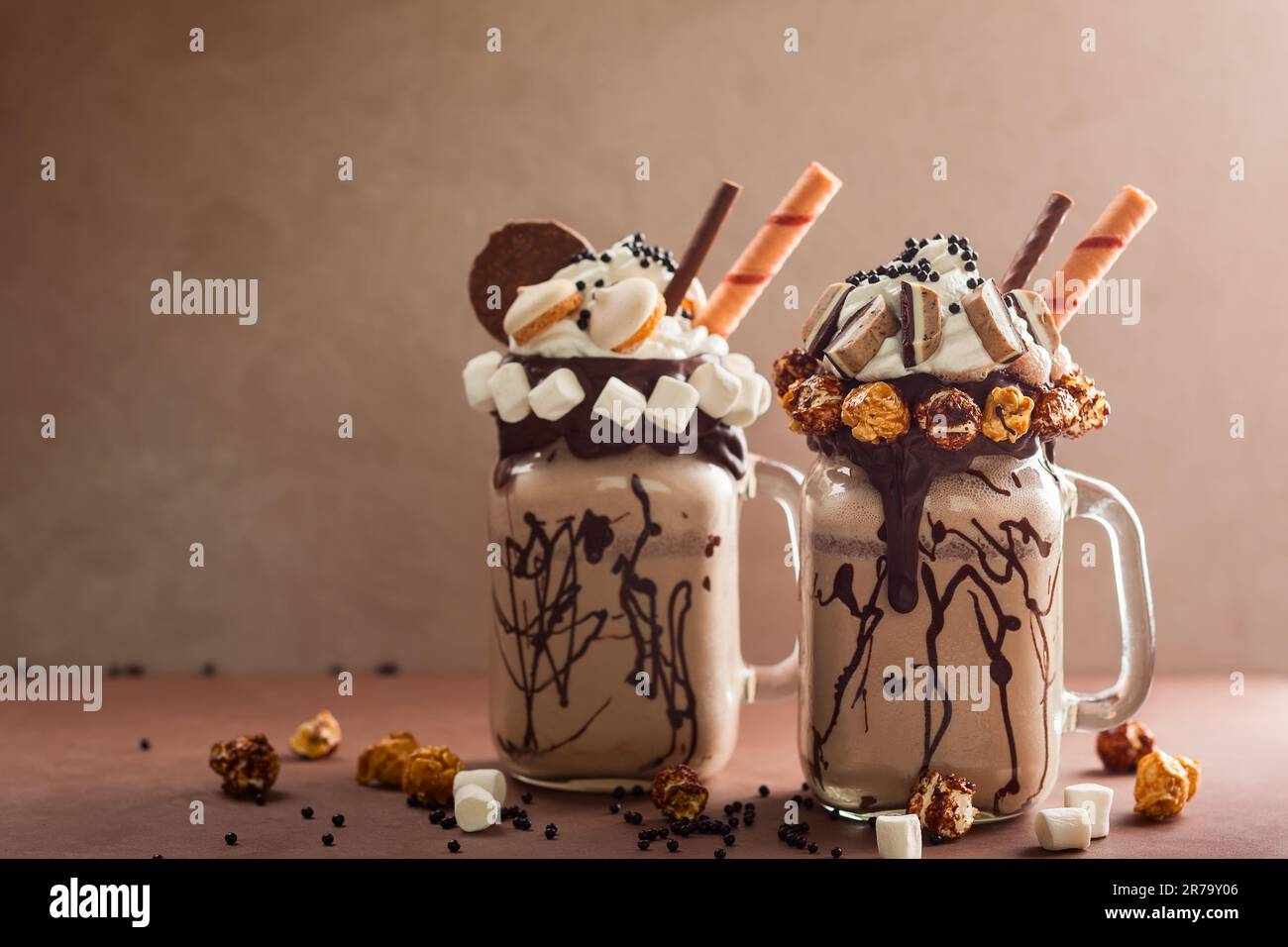 Schokoladenmilchshake mit Eiscreme und mit Schlagsahne, Marshmallow, süßem Popcorn, Keksen, Waffeln, Serviert in einem Glasbecher. „Freak or Crazy“ Stockfoto