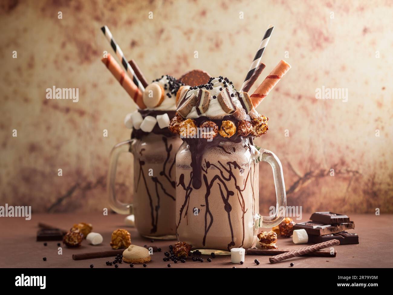 Schokoladenmilchshake mit Eiscreme und mit Schlagsahne, Marshmallow, süßem Popcorn, Keksen, Waffeln, Serviert in einem Glasbecher. „Freak or Crazy“ Stockfoto