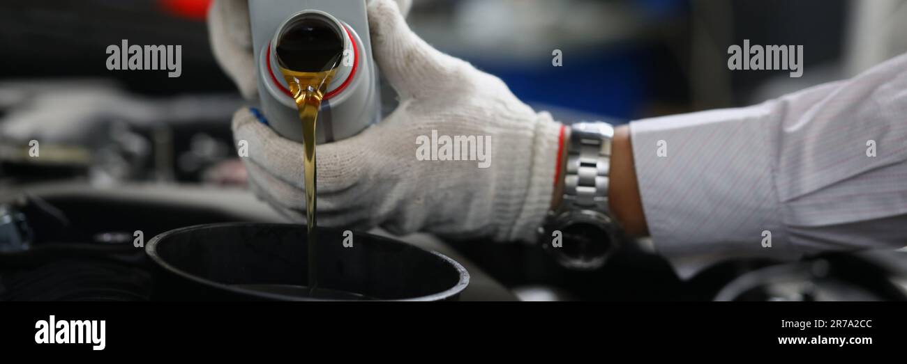 Automechaniker gießt Motoröl in die Fahrzeugschließung Stockfoto