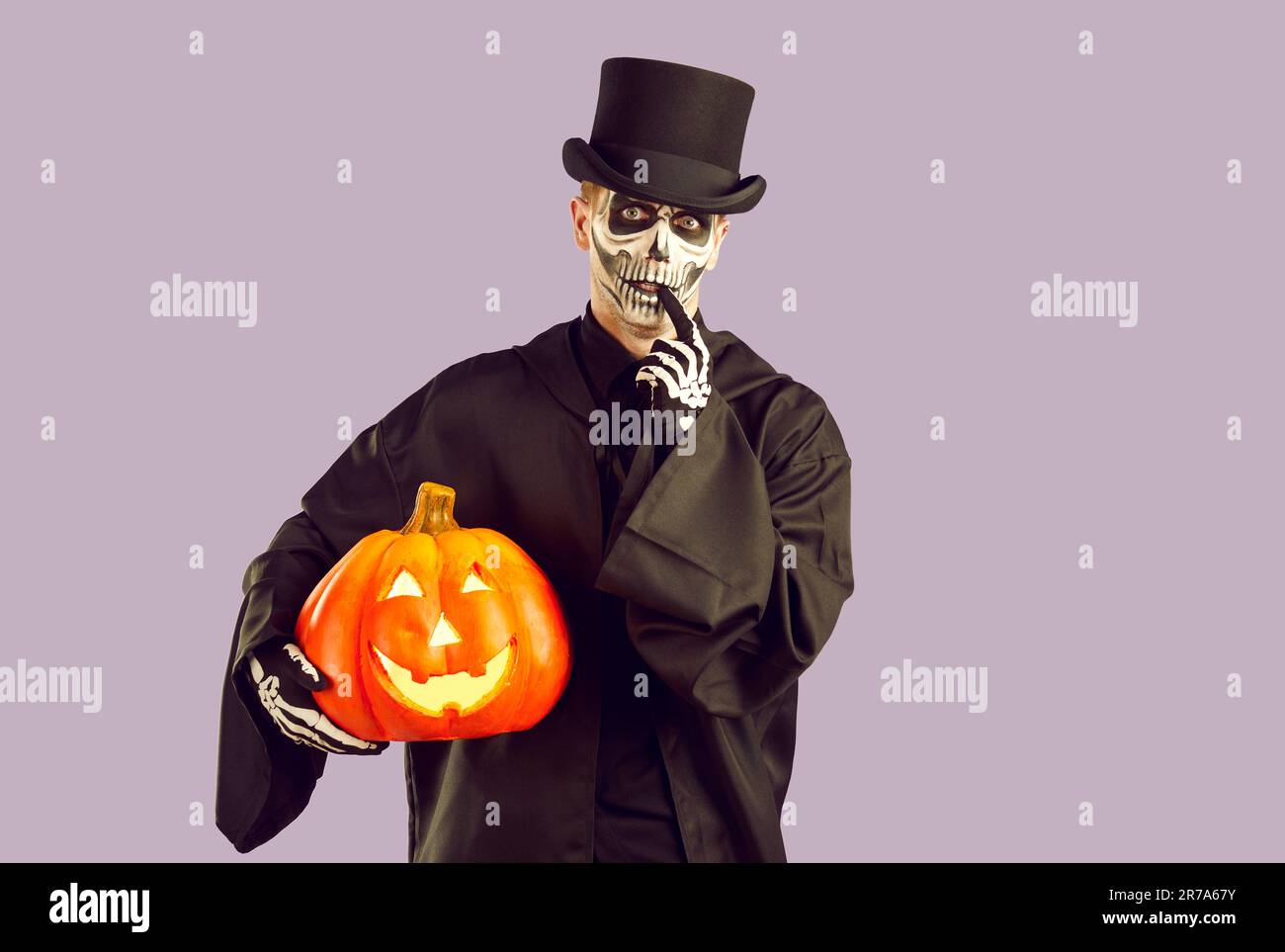 Ein Mann in Halloween-Outfit sieht dich mit einem lustigen, schuldigen Ausdruck auf lila Hintergrund an. Stockfoto