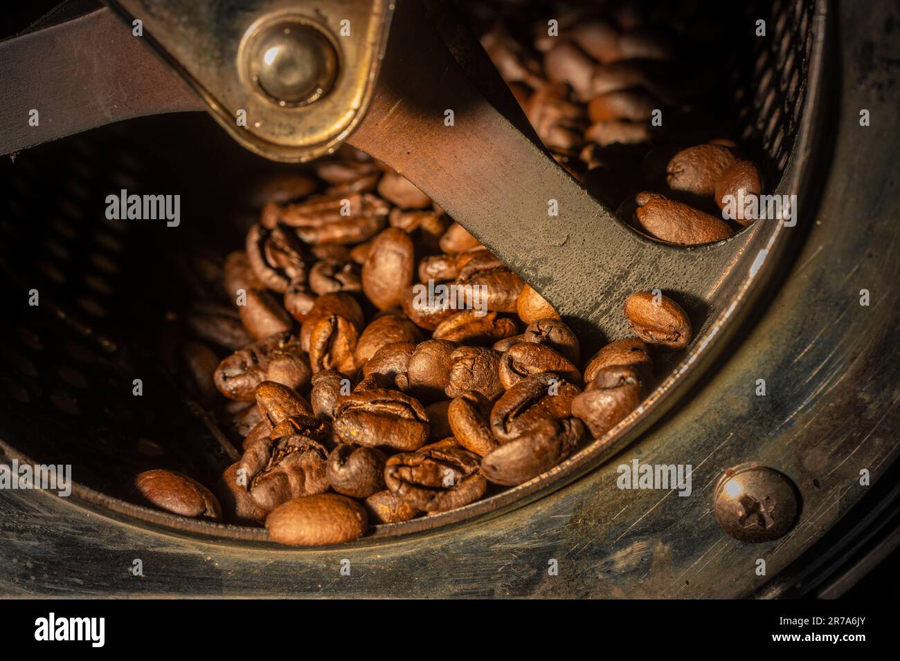 Nahaufnahme von Kaffeebohnen, die in der Trommel einer Rösterei geröstet werden. Stockfoto