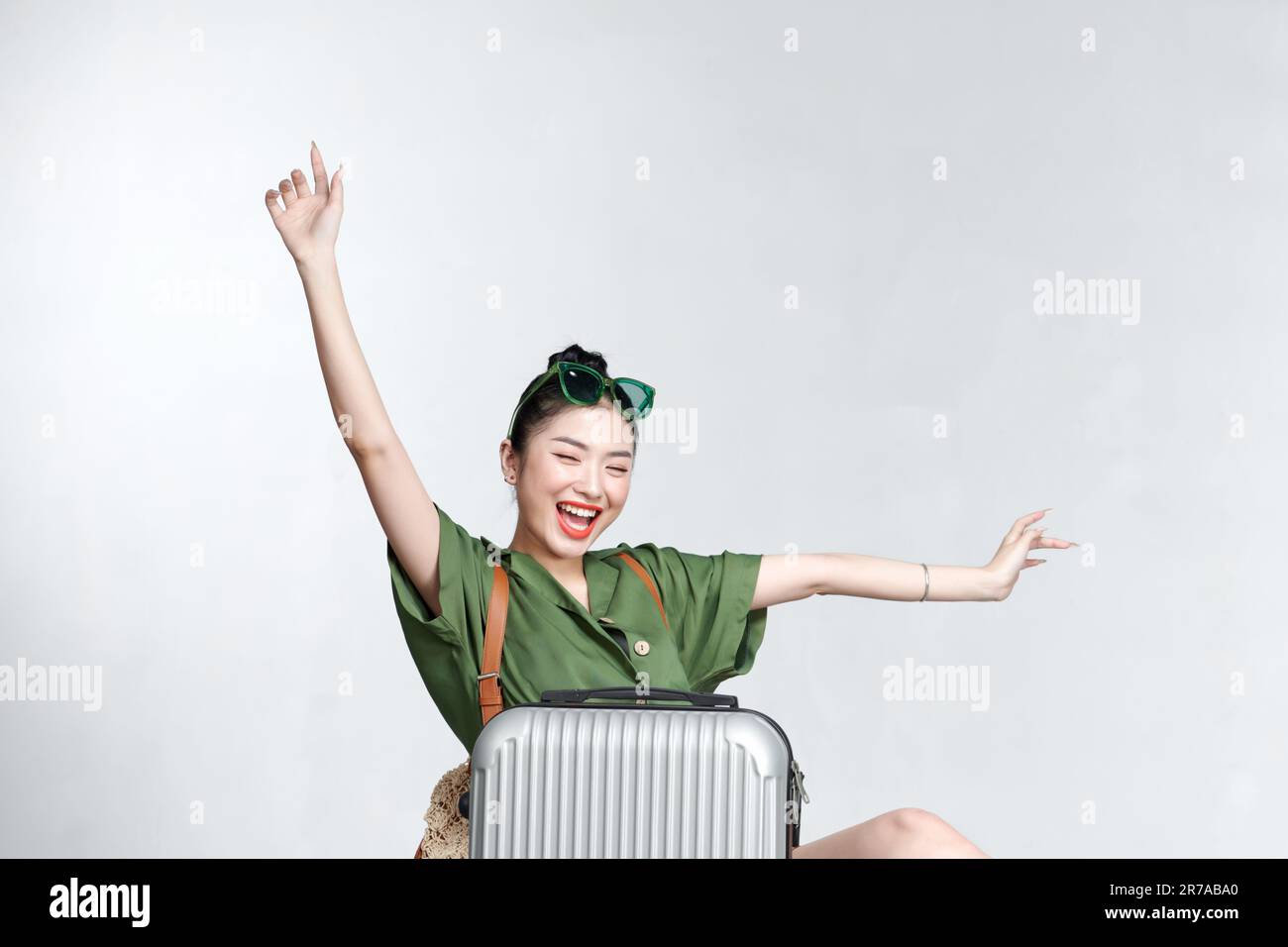 Junge Touristin, die sich zurücklehnt und vorgibt, in einem Flugzeug zu fliegen, Stockfoto