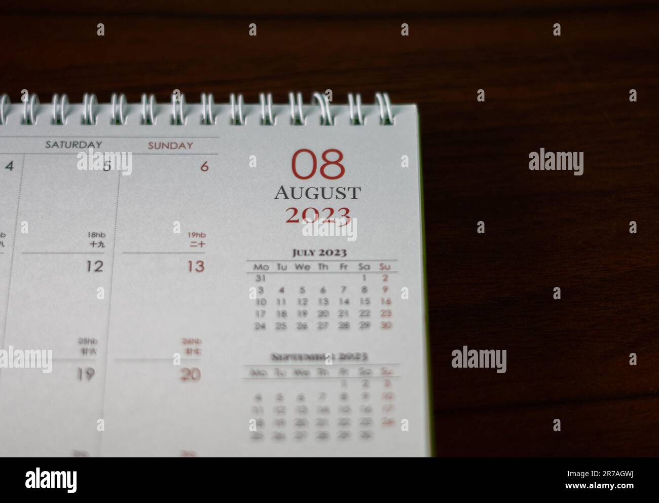 Nahaufnahme eines Tischkalenders, der auf einer Holzfläche geöffnet ist und ein Datum auf der Seite zeigt Stockfoto