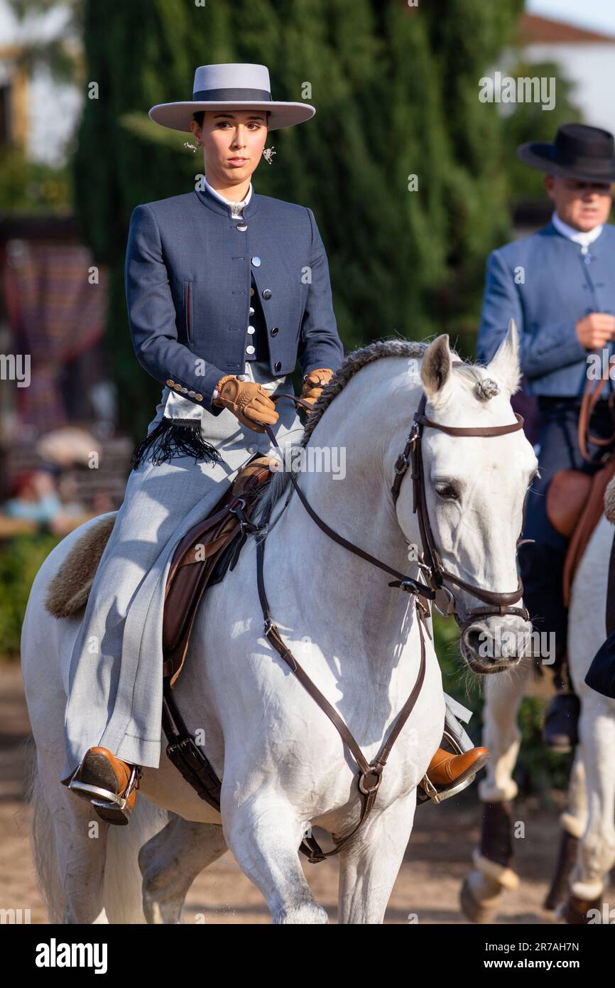 Europa, Portugal, Alentejo Region, Golega, Frau reitet weißes Lusitano Pferd und trägt traditionelles Kostüm auf der Golega Horse Fair 2022 Stockfoto