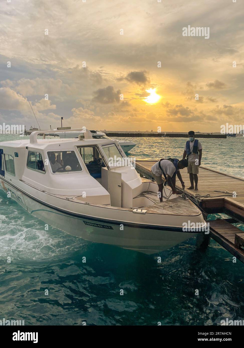 Hulhumale, Malediven - 1. Mai 2022 : Ein Motorboot oder Schnellboot, mit dem Menschen zu privaten Inselresorts gebracht werden, wird an einem Holzsteg festgemacht. Stockfoto