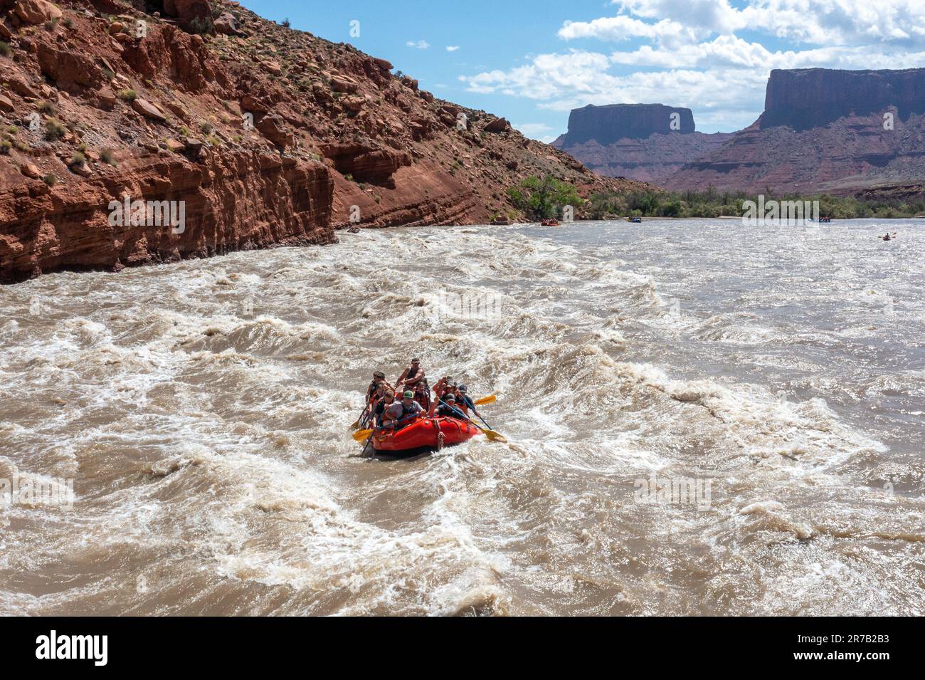 Touristen genießen eine Rafting-Tour durch die großen Wellen in White's Rapid auf dem Colorado River im Hochwasser. Moab, Utah. Stockfoto