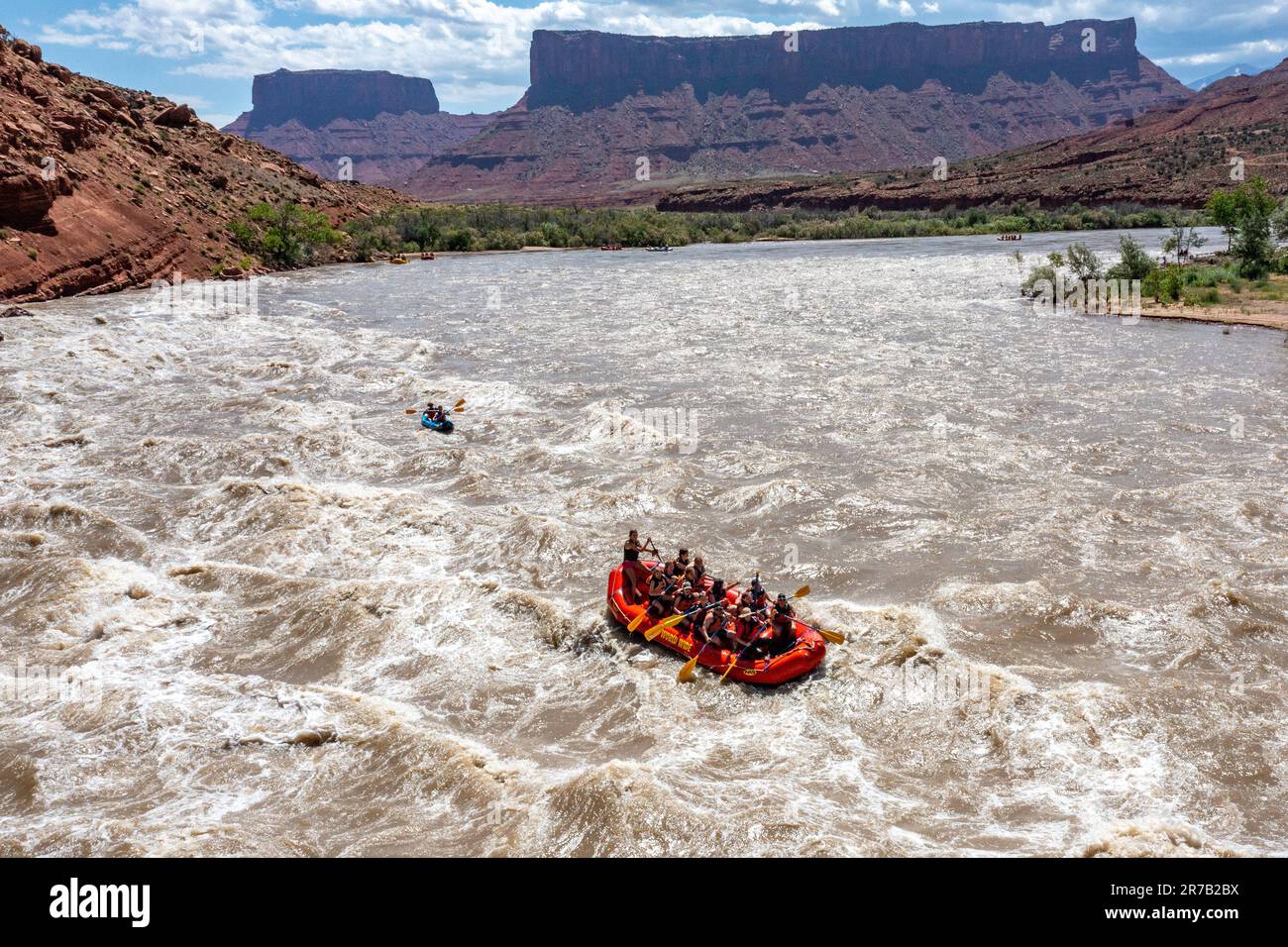 Touristen genießen eine Rafting-Tour durch die großen Wellen in White's Rapid auf dem Colorado River im Hochwasser. Moab, Utah. Stockfoto