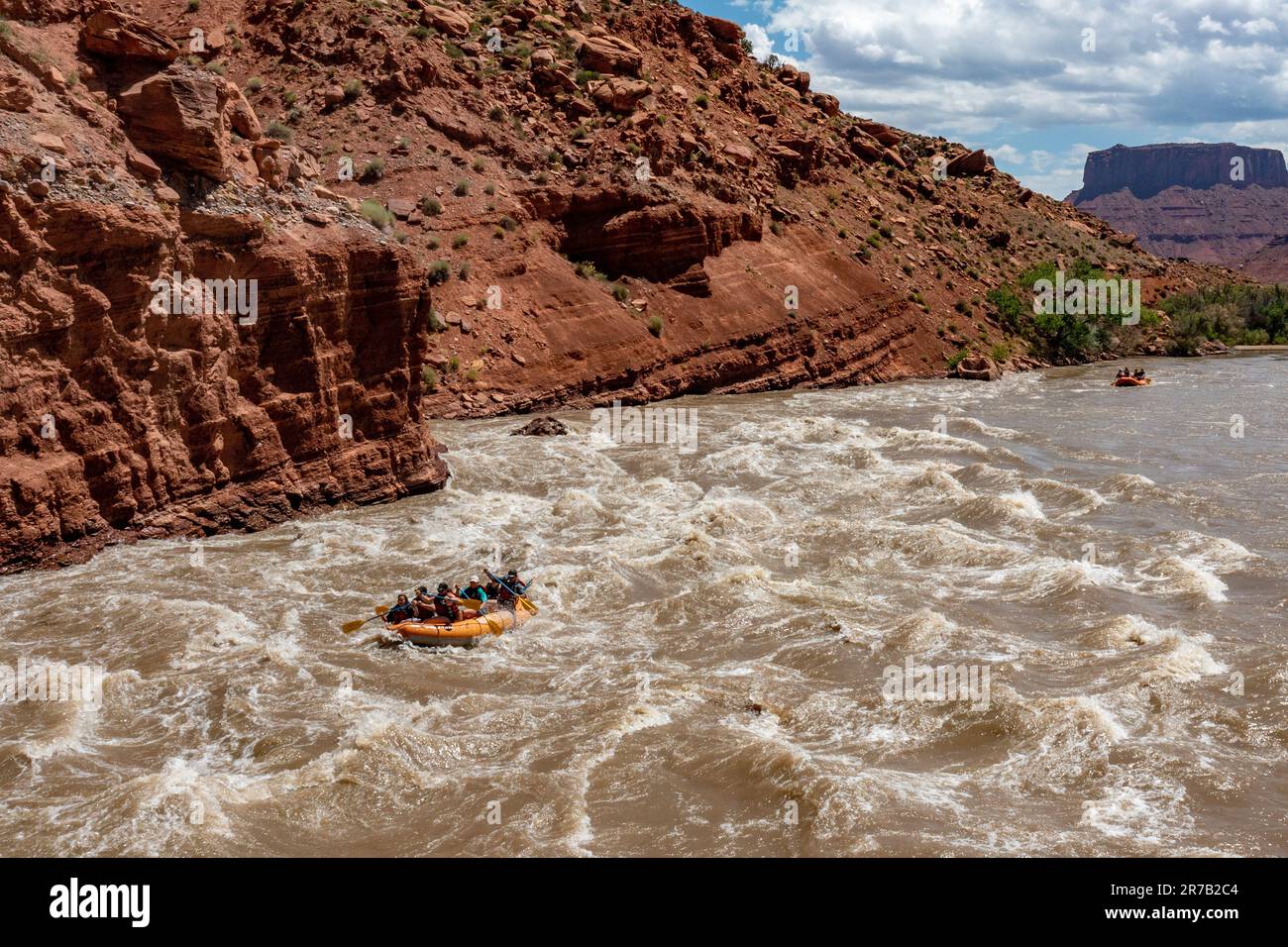 Touristen genießen eine Rafting-Tour durch die großen Wellen in White's Rapid auf dem Colorado River im Hochwasser. Moab, Utah. Stockfoto