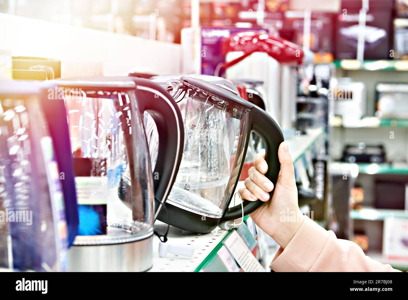 Elektrischer Wasserkocher in der Hand des Käufers im Geschäft Stockfoto