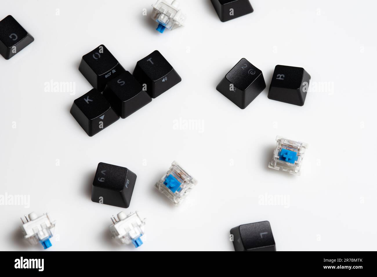 Verstreute Tastenkappen und Schlüsselschalter für mechanische Tastaturen auf weißem Hintergrund Stockfoto