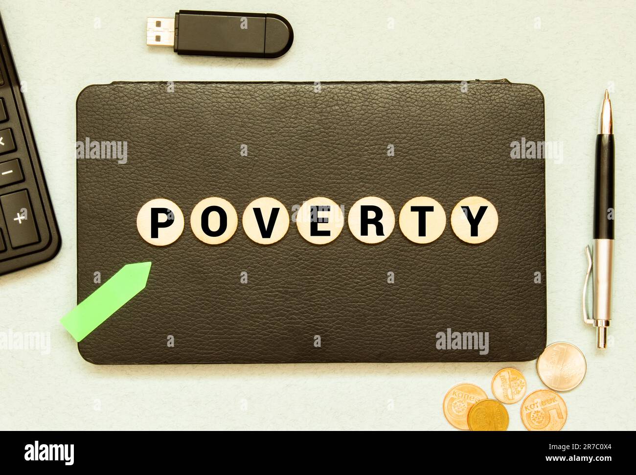 Gelber Zettel auf einem Geldhintergrund in USD. Die Inschrift Armut auf einem gelben Erinnerungsstickzettel. Schließen Stockfoto