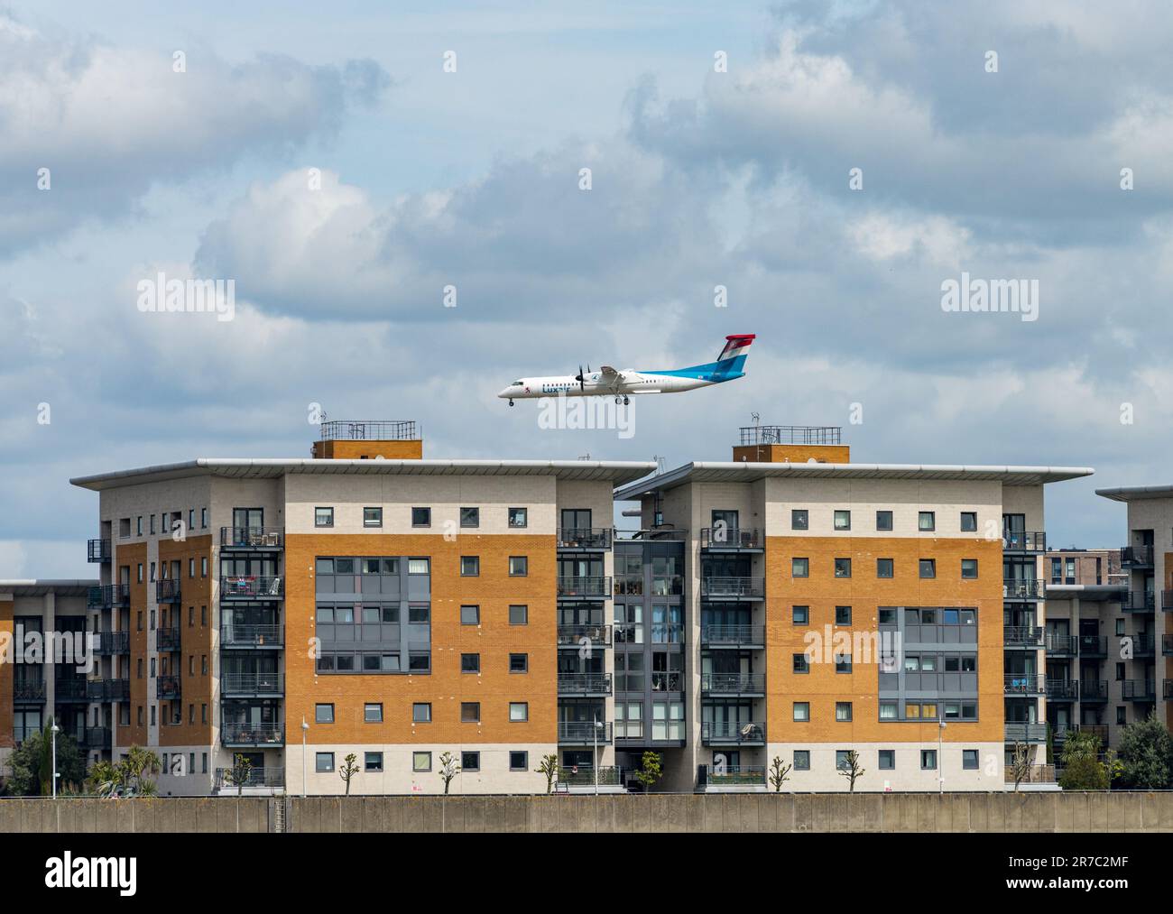 Woolwich, London - 15. Mai 2023: Luxair-Flugzeug fliegt tief über den Apartmentblock und landet am City Airport Stockfoto