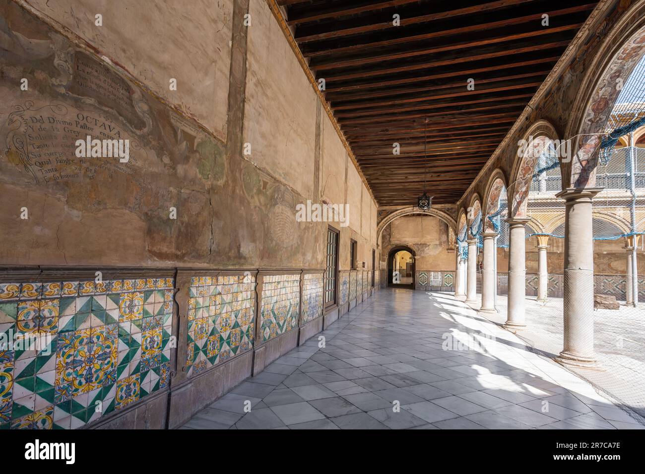 Wand mit Gemälden und Fliesen im Innenhof des San Juan de Dios Hospital - Granada, Andalusien, Spanien Stockfoto