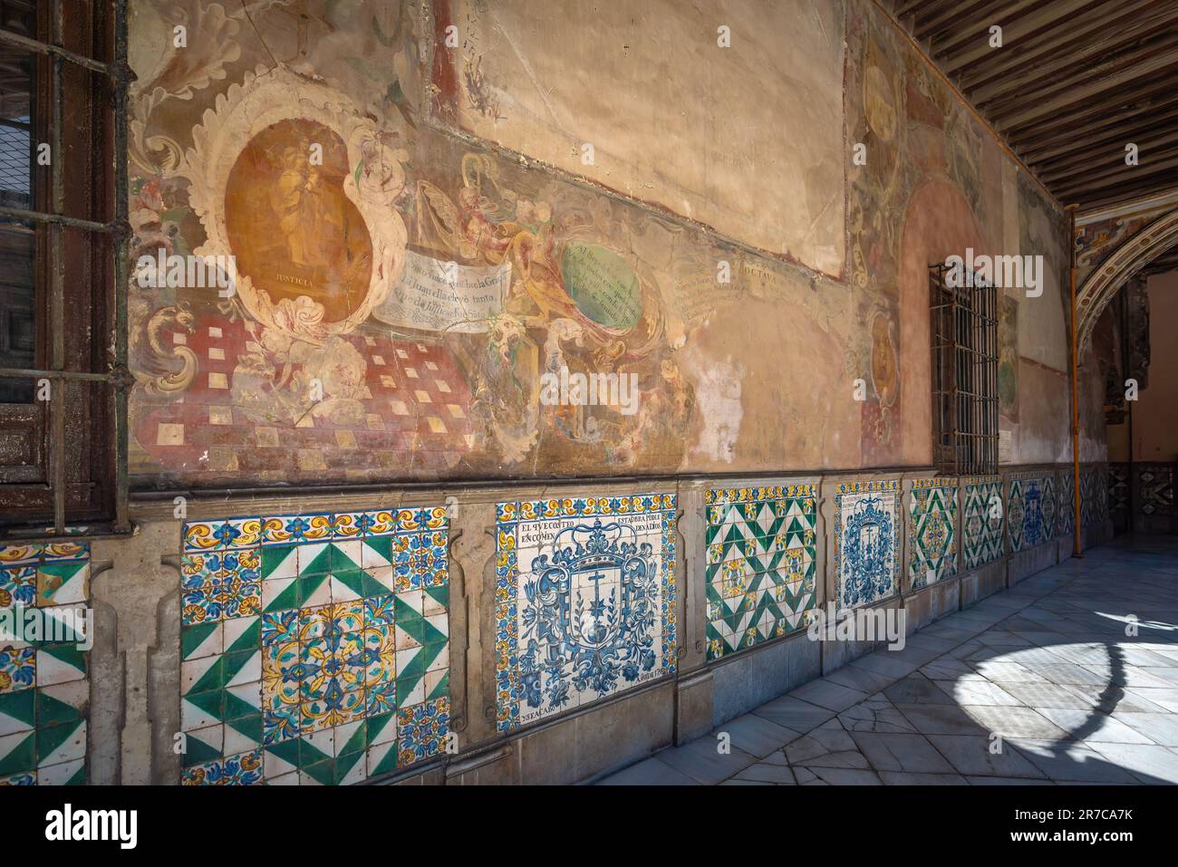 Wand mit Gemälden und Fliesen im Innenhof des San Juan de Dios Hospital - Granada, Andalusien, Spanien Stockfoto