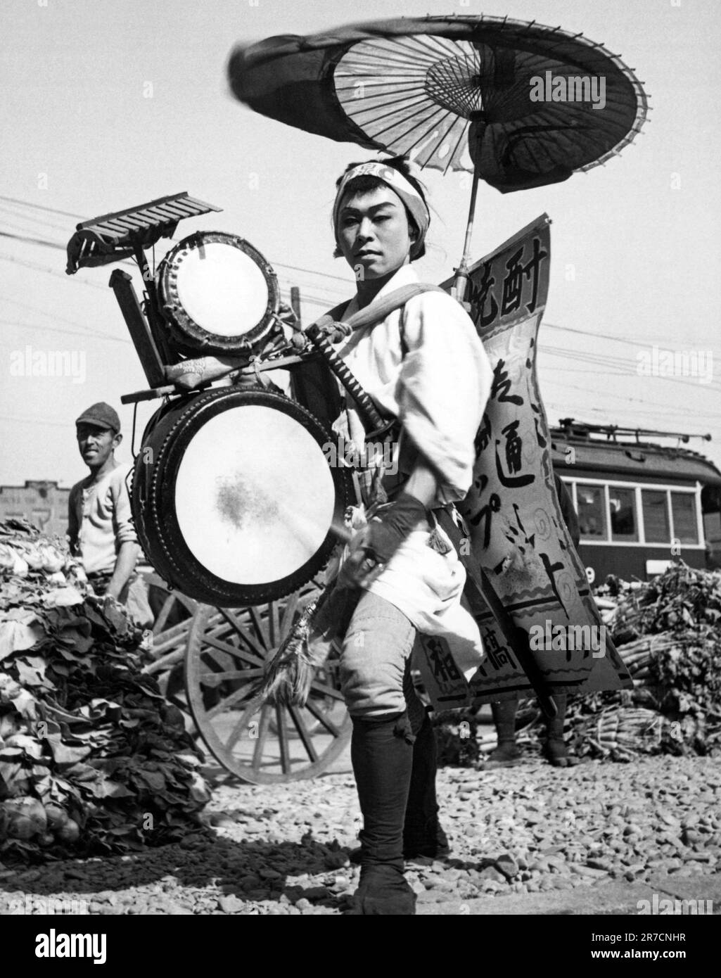 Tokio, Japan, 14. Mai 1947. Eine japanische ein-Mann-Band und wandelnde Werbung in Form einer „Chindonya-Hiromeya“, was übersetzt bedeutet „einer, der viele Instrumente spielt und Nachrichten verbreitet“. Stockfoto