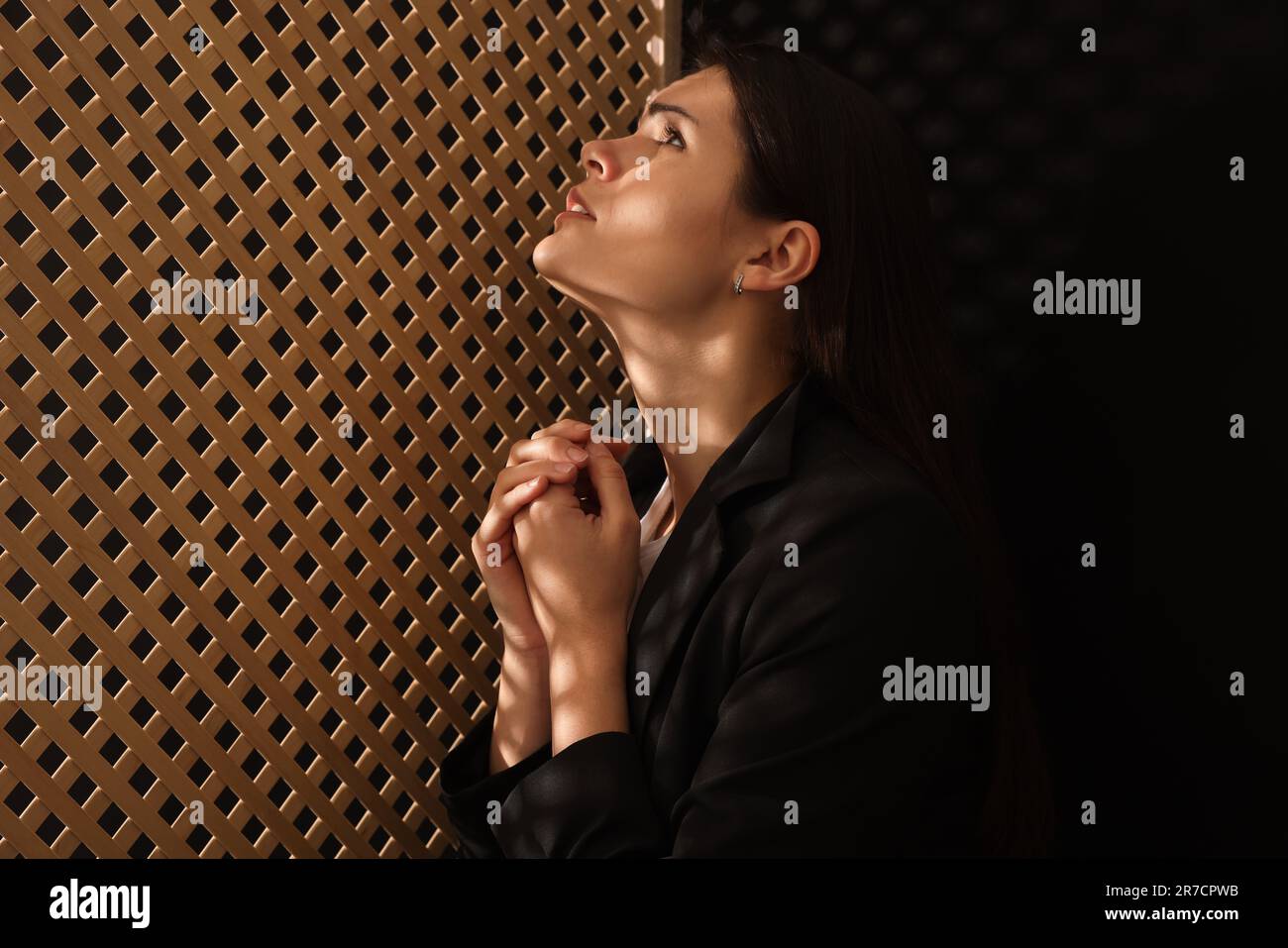 Eine Frau, die während der Beichte zu Gott betet Stockfoto