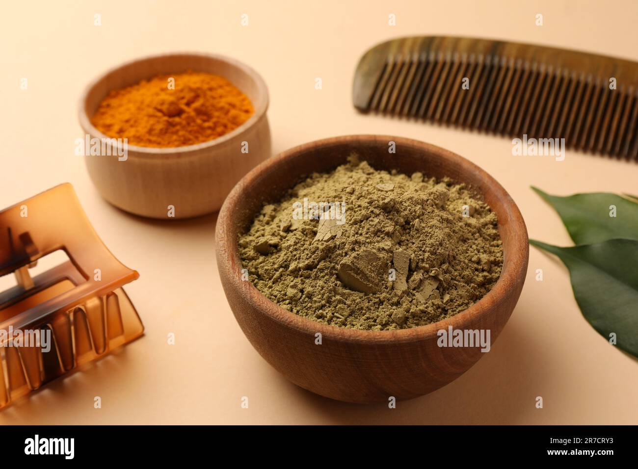 Kamm, Haarspange, Henna und Kurkumapulver auf beigefarbenem Hintergrund, Nahaufnahme. Natürliche Haarfarbe Stockfoto