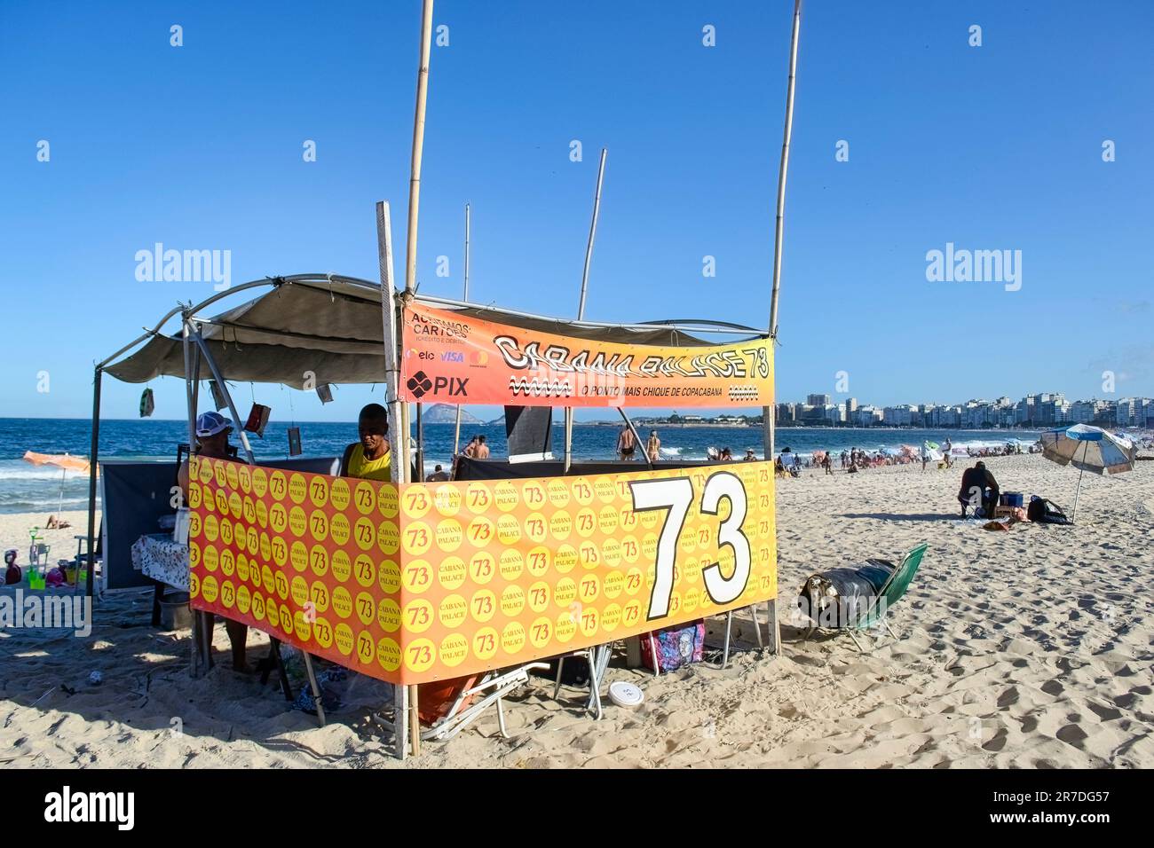 Rio de Janeiro, Brasilien - 25. Mai 2023: Zwei Personen befinden sich in einem Stall am Copacabana Beach, mit einem Stoff mit der Nummer 73. Der Hintergrund zeigt b Stockfoto