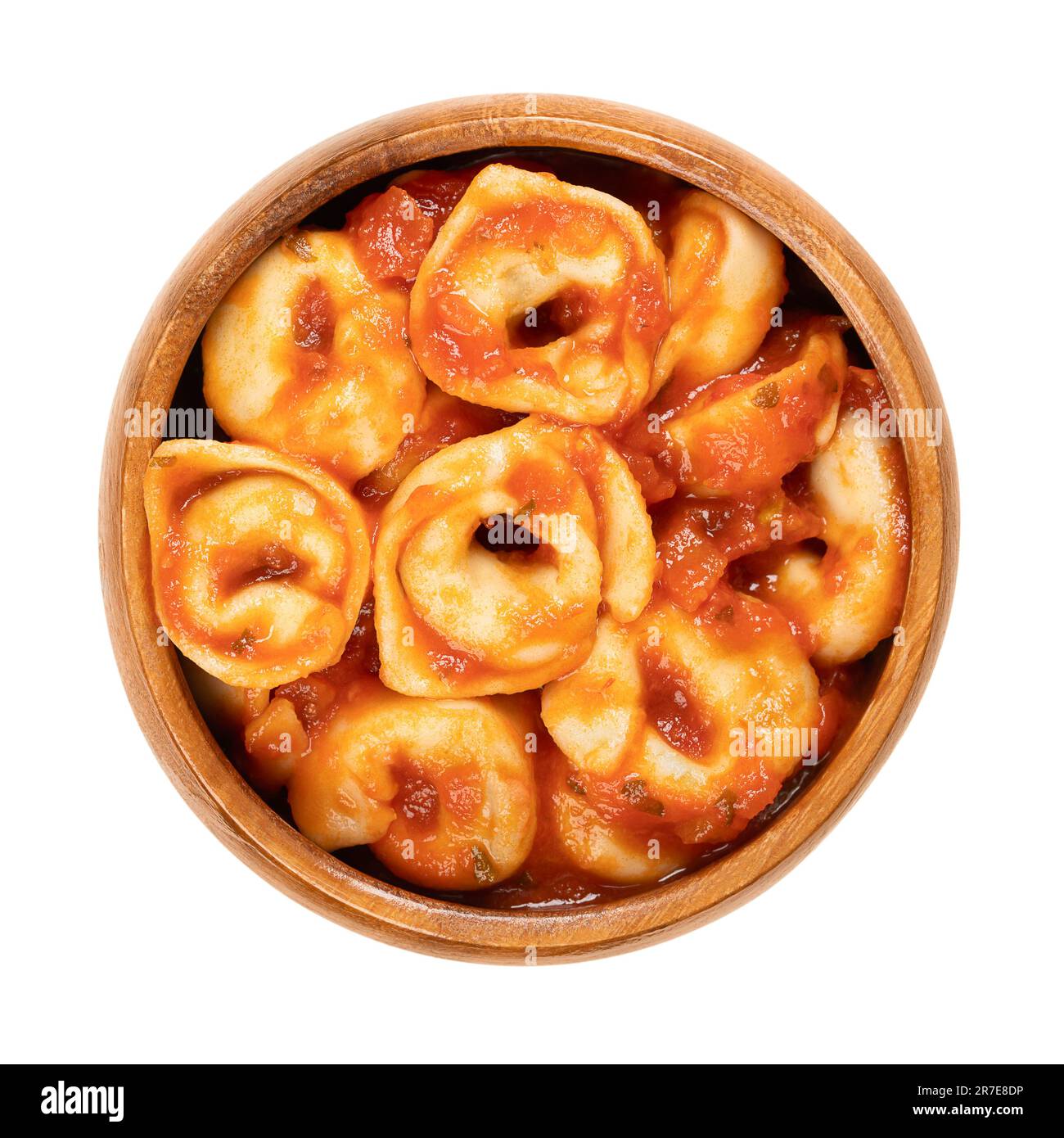 Gekochte Tortellini in Tomatensoße, in einer Holzschüssel. Industriell gefertigte gefüllte Knödel. Italienische Pasta aus Hartweizengrieß. Stockfoto