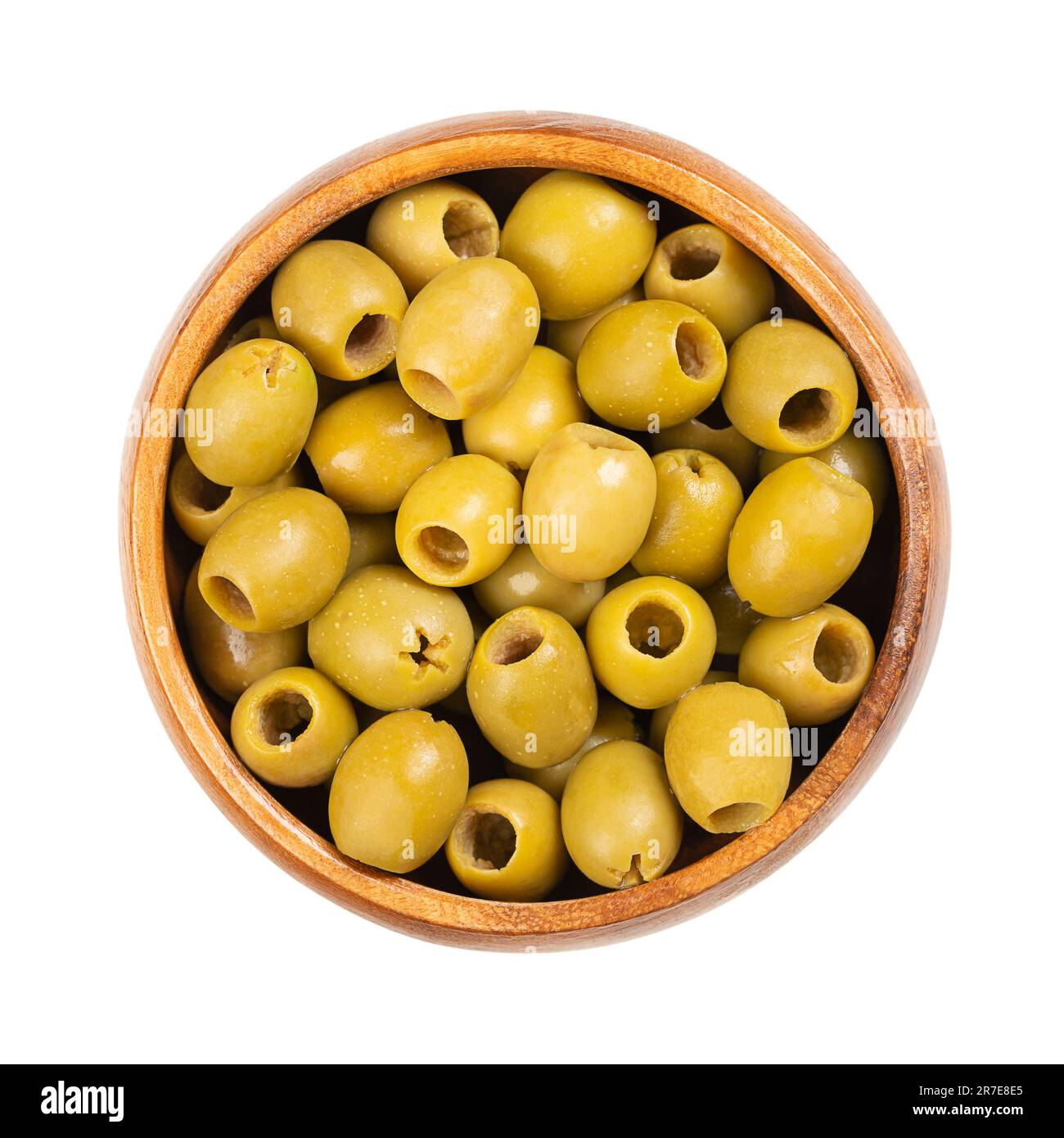 Entsteinte grüne Oliven zum Snack, in einer Holzschüssel. Verzehrfertig, kleine Tafeloliven aus Spanien, nach Entfernung des Kerns verarbeitet, in Salzlake haltbar gemacht. Stockfoto