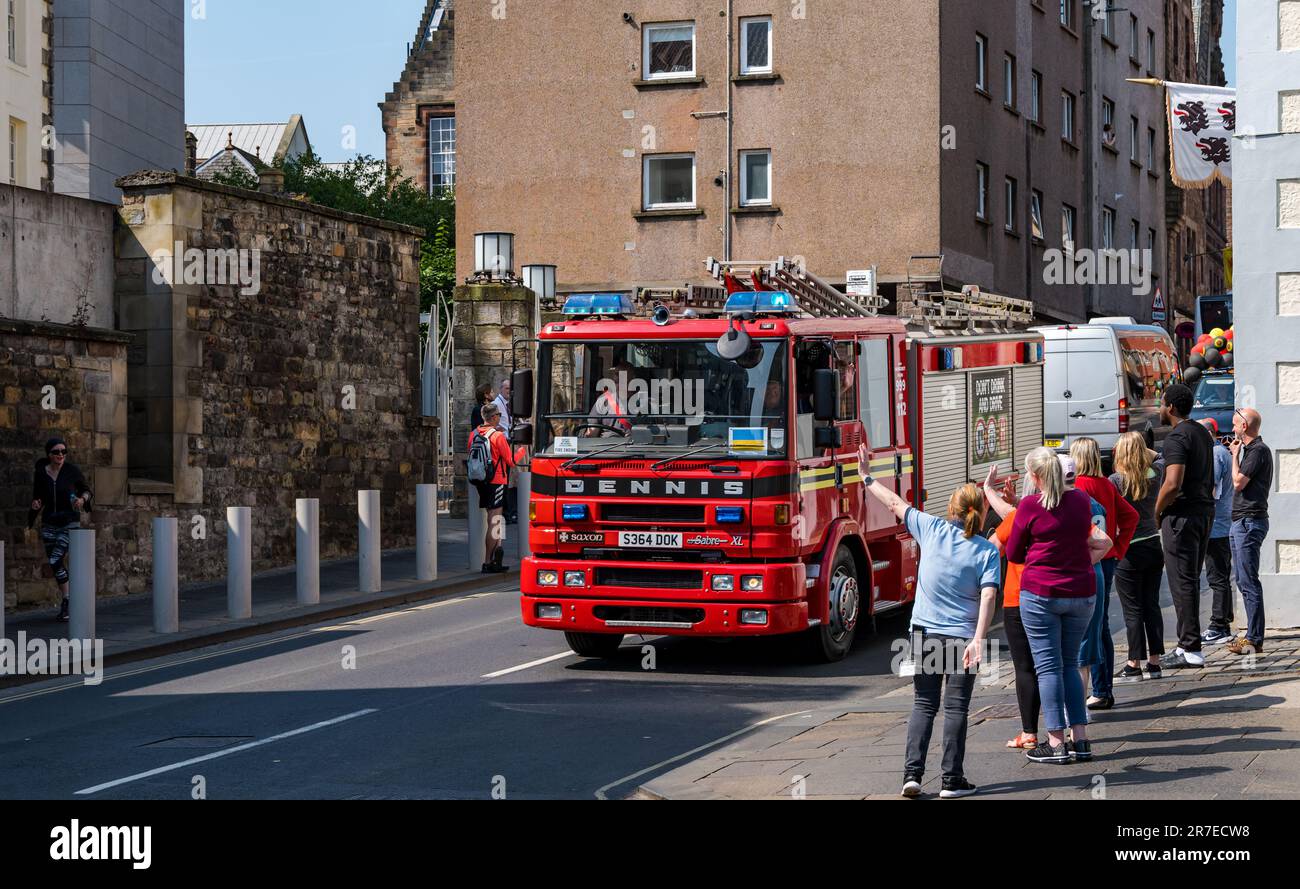 Menschen winken zu schottischem Feuerwehrwagen oder Lkw in Edinburgh Taxi Outing, Royal Mile, Edinburgh, Schottland, Großbritannien Stockfoto