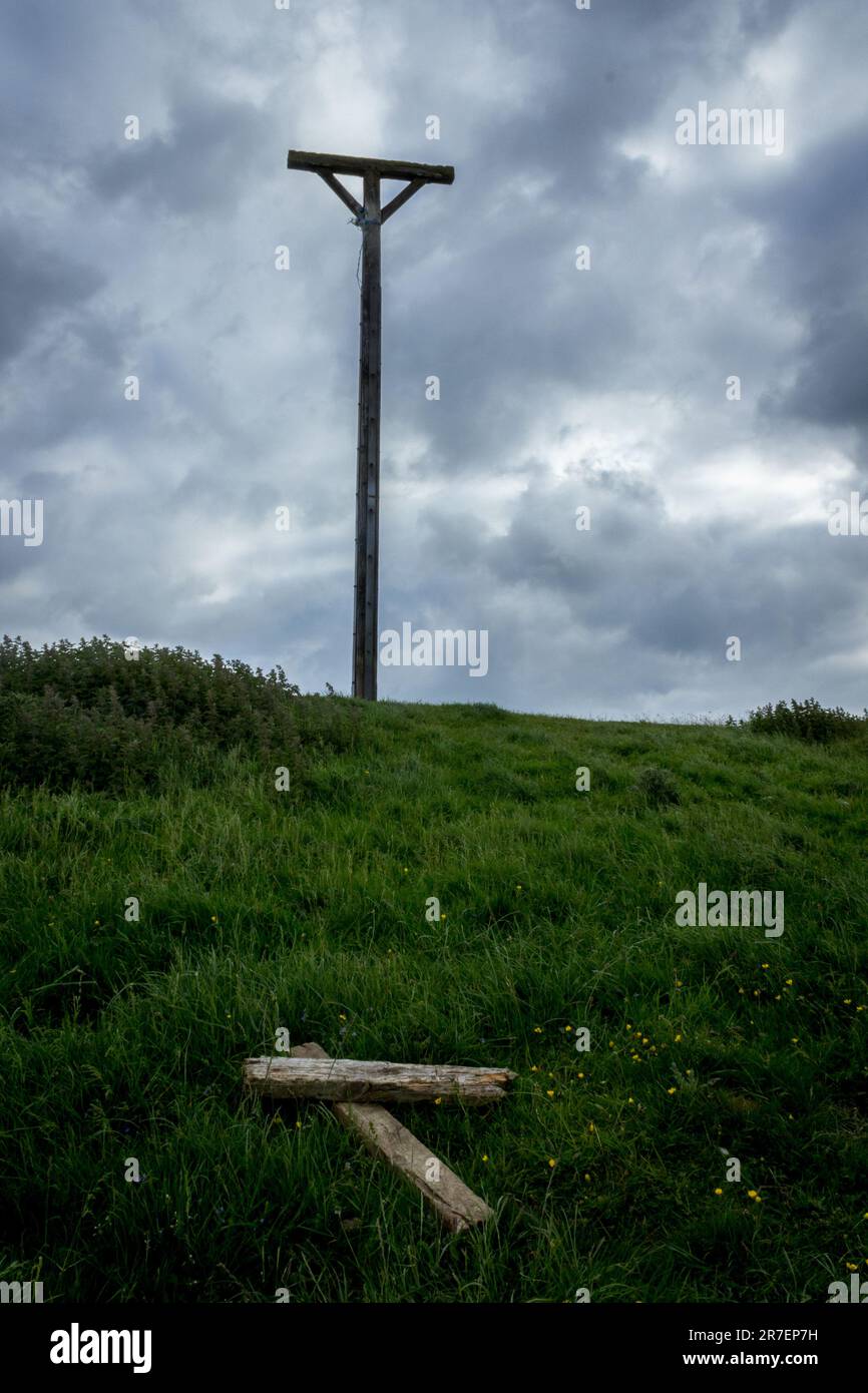 Ein Blick auf den Coombe Gibbet auf Gallows Down, Berkshire, vor einem wolkigen Himmel mit verworfenen Holzplanken im Vordergrund. Hochformat Stockfoto