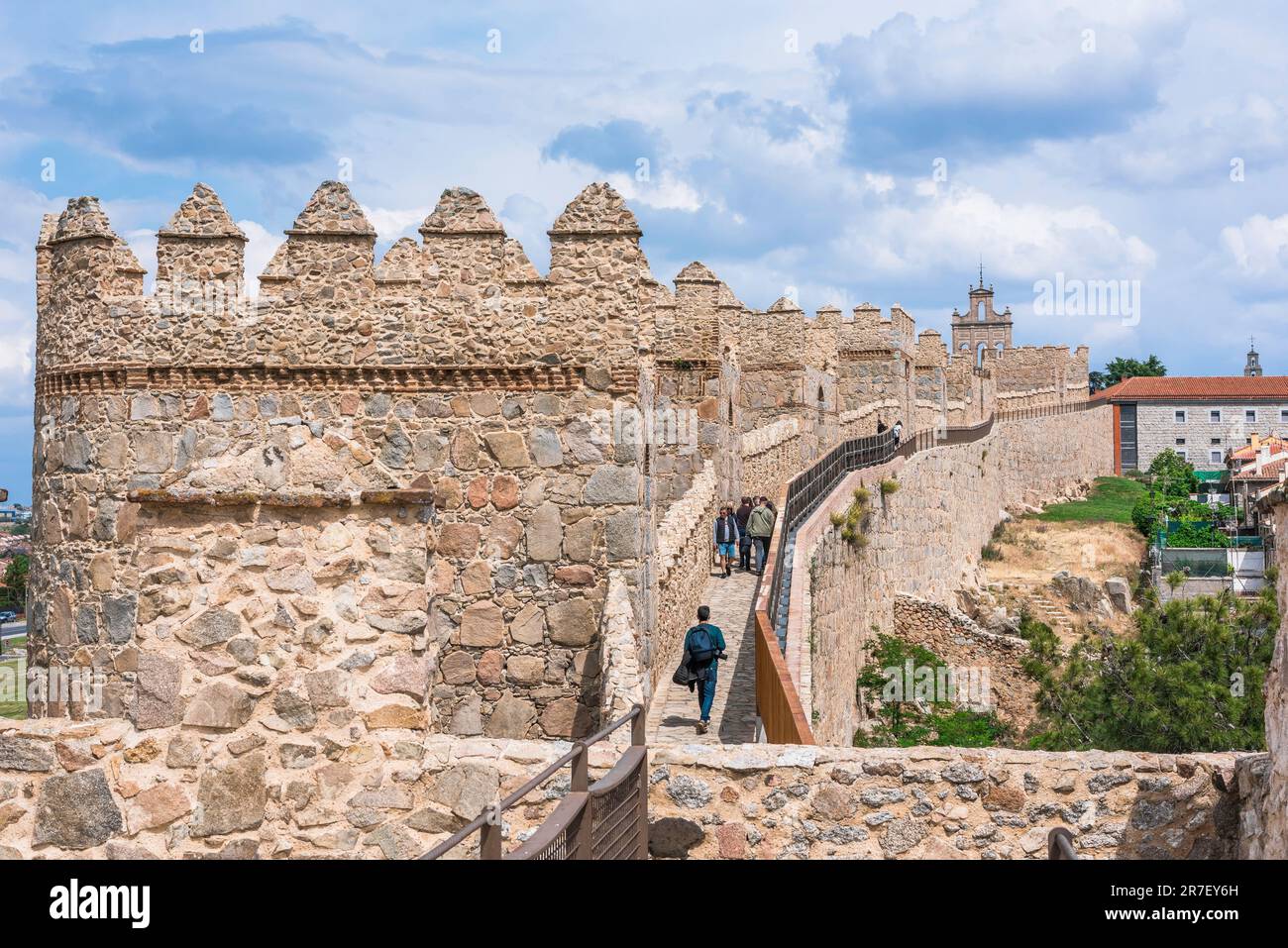 Avila Mauer, im Sommer sehen Sie, wie Menschen die sorgfältig erhaltene mittelalterliche Mauer erkunden, die die Stadt Avila in Zentralspanien umgibt. Stockfoto