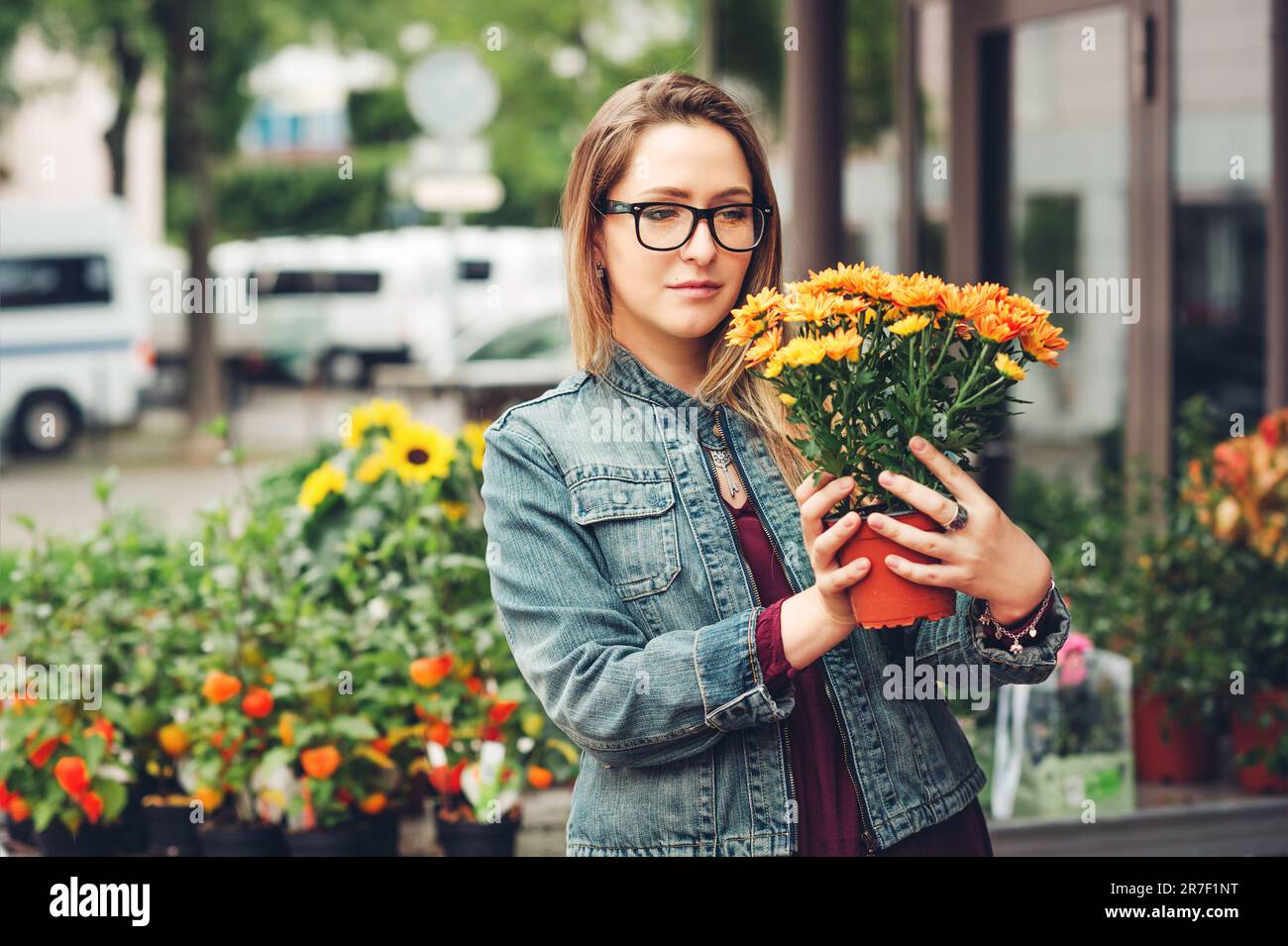 Eine Frau, die Blumen in Töpfen im Blumenladen kauft Stockfoto