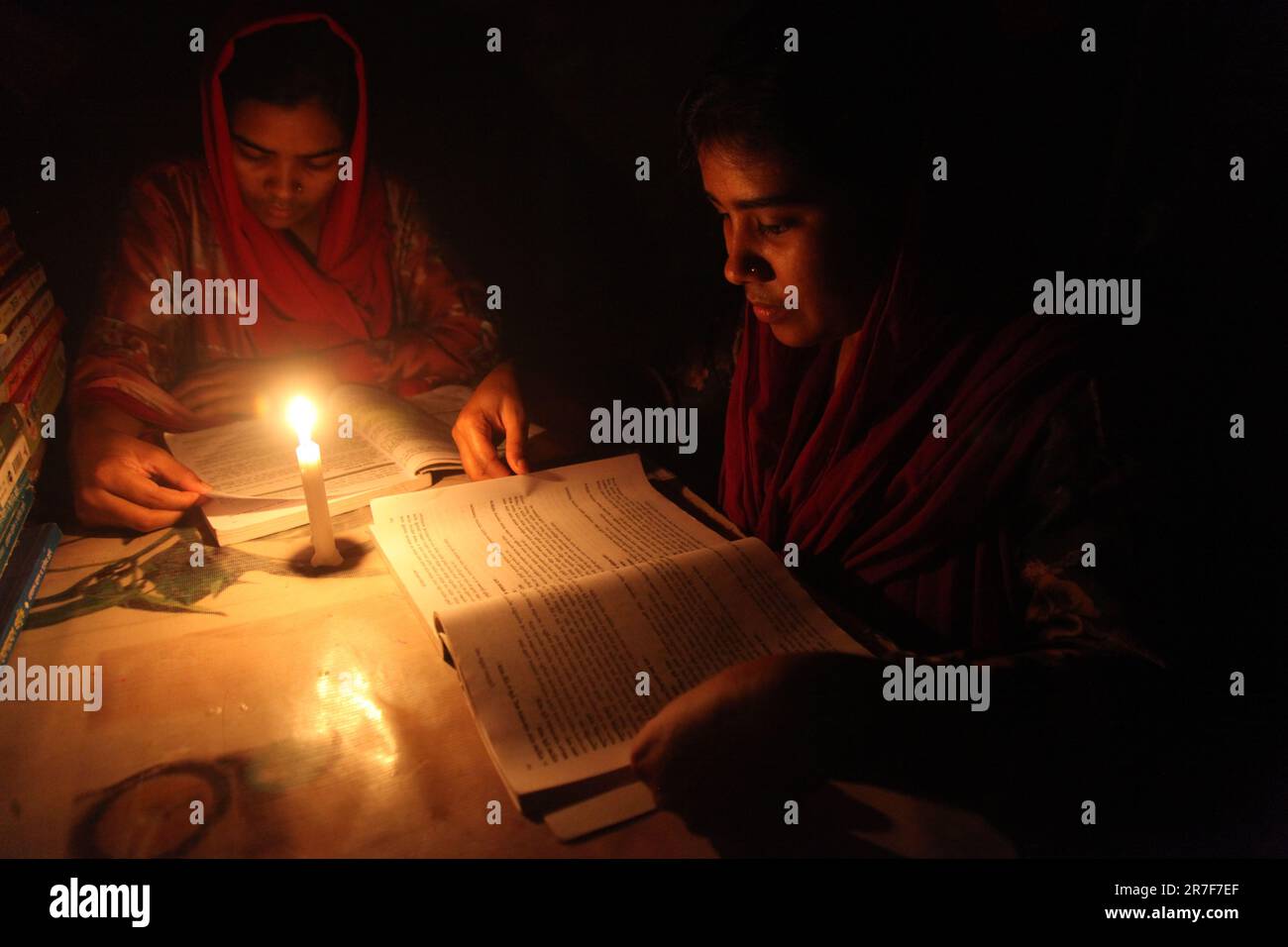 Juni 05,2023, Dhaka Bangladesch. Menschen werden durch starke Lastabwurf unruhig. Zwei Studenten zünden Kerzen an, um zu lernen. Nazmul islam/ Stockfoto