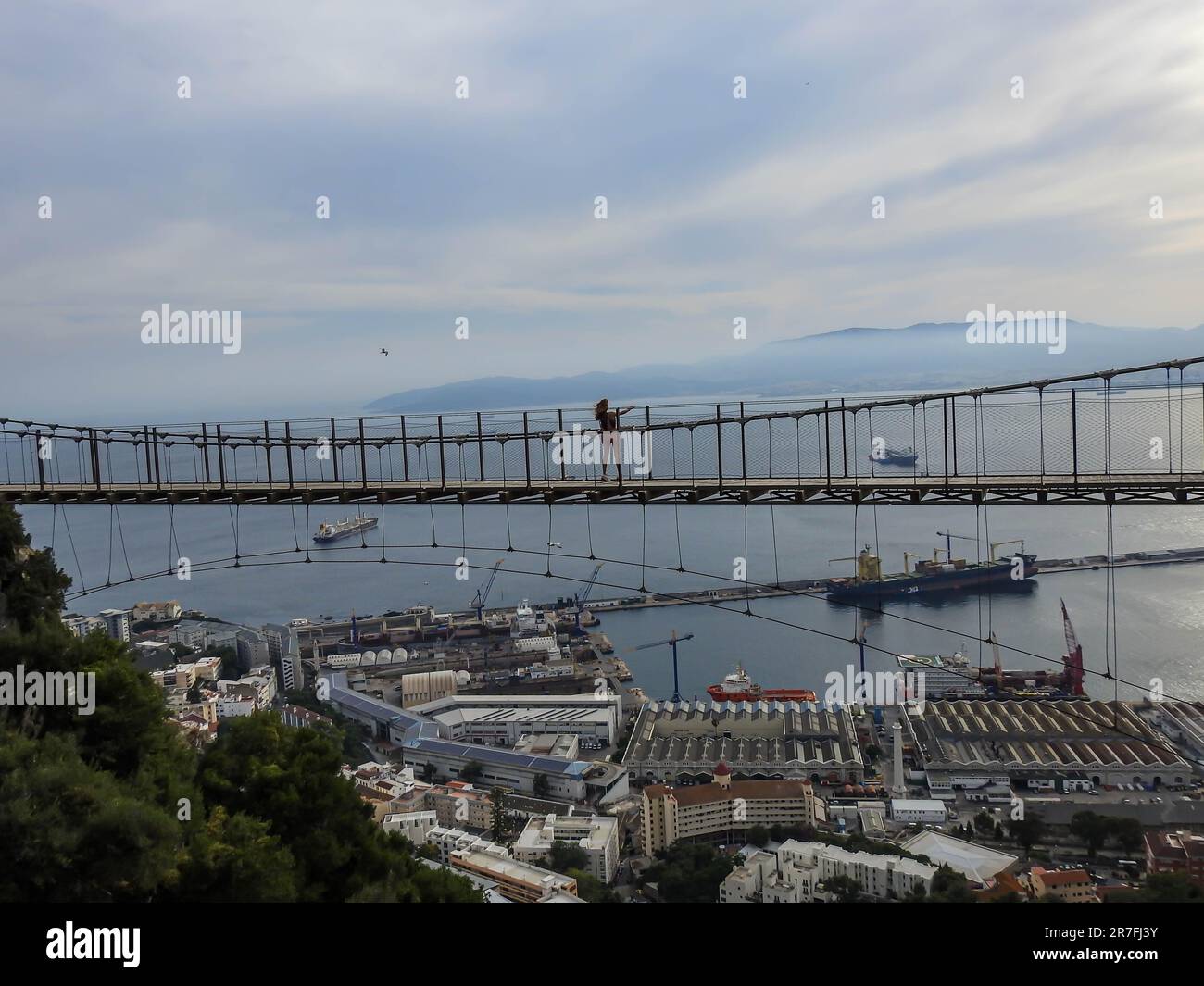 Dieses Stockfoto zeigt eine große Brücke, die in der Luft hängt, mit einem atemberaubenden Blick auf Gibraltar im Hintergrund Stockfoto