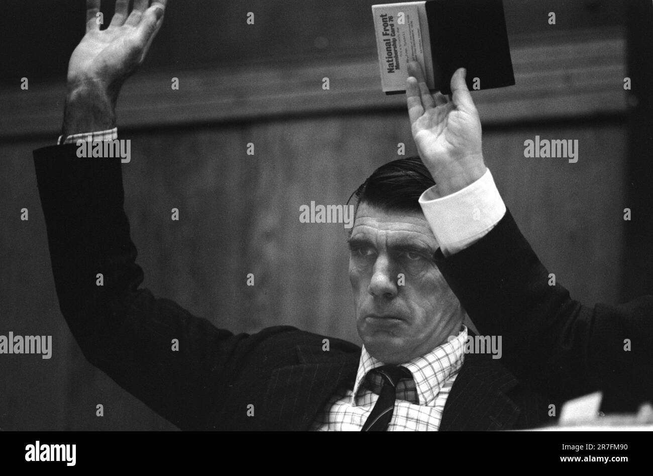 Andrew Fountaine, ein Senior-Mitglied der Front National, hebt eine Hand, ebenso John Tyndall, der (nicht gesehen) seine Mitgliedskarte der Front National hält. Die nationale Front trifft sich nach märz durch Birmingham Vorort Walsall North während einer durch Wahlen. Walsall, Birmingham, England 1976. Rassismus 1970er Jahre, britischer HOMER SYKES Stockfoto