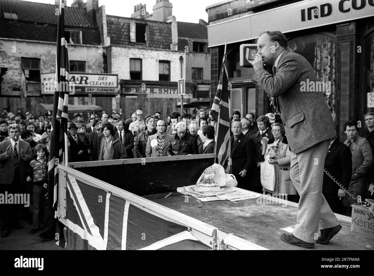 John Tyndall, Anführer der Front National, Hoxton, East London, England 1976. Eine rassistischste Anti-Einwanderungspartei, die Unterstützung von einem Lastwagen sammelt, verziert mit Union Jack Flaggen auf dem Samstag Hoxton Street Market am 27. November. Sein Publikum ist fast ausschließlich männlich. GROSSBRITANNIEN 1970ER JAHRE HOMER SYKES Stockfoto