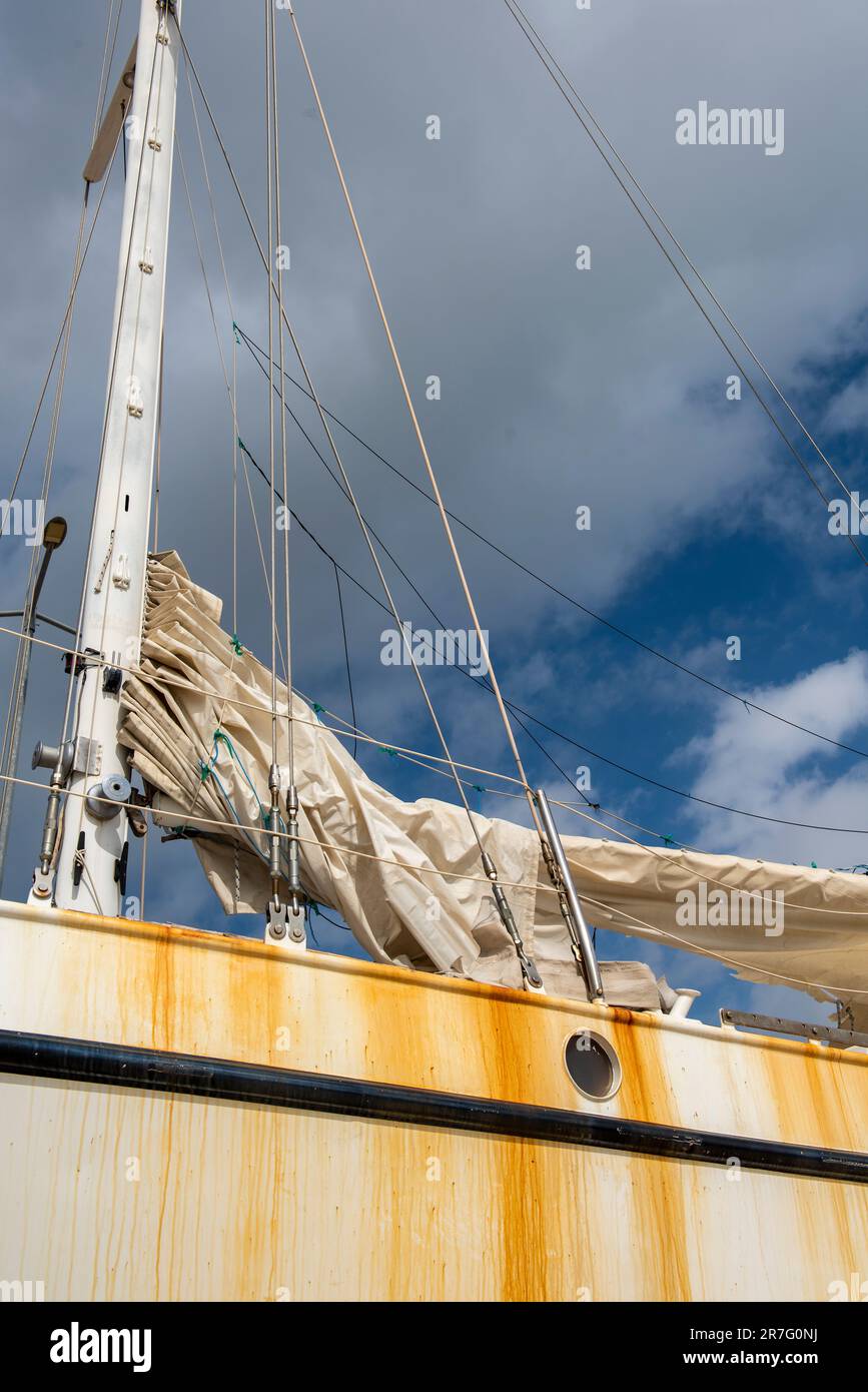 Altes Segelboot auf hartem Stand, Nahaufnahme von unbenutzter verrottender Segelyacht, stillgelegte Yacht, verfallenes Boot, rostige Bullaugen auf dem Schiff Stockfoto