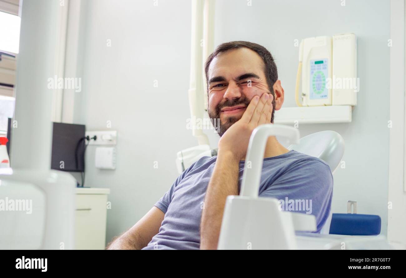 Patient hat Zahnschmerzen beim Zahnarzt und wartet auf Hilfe Stockfoto
