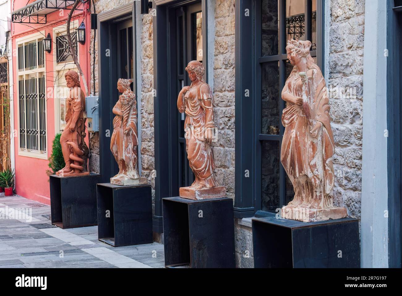 Alte griechische Statuen in Originalgröße vor einer Ladenfassade in Nafplio, Griechenland. Stockfoto