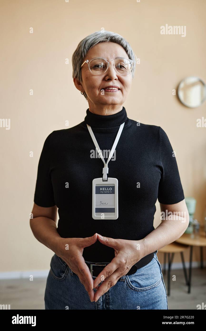 Taillenhochporträt einer modernen asiatischen Seniorin in der Selbsthilfegruppe Stockfoto