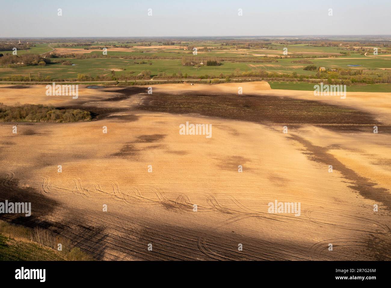 Drohnenfotografie von Ackerland- und Traktorreifenspuren am Frühlingssonntag. Stockfoto