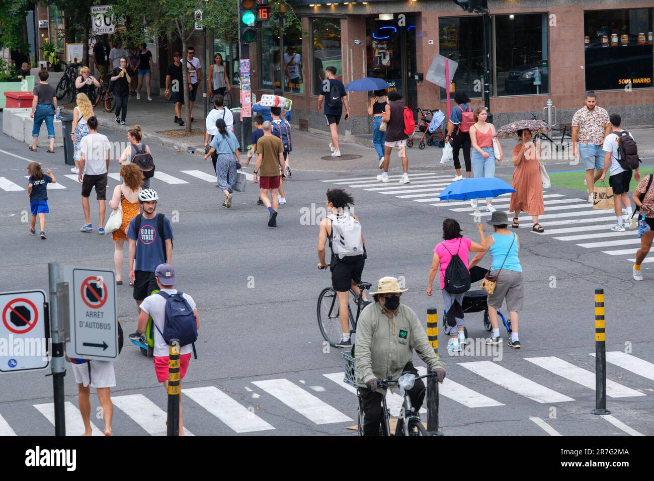 Montreal, CA - 15. Juni 2022: Personen, die die Straße auf der Mont-Royal Avenue überqueren Stockfoto