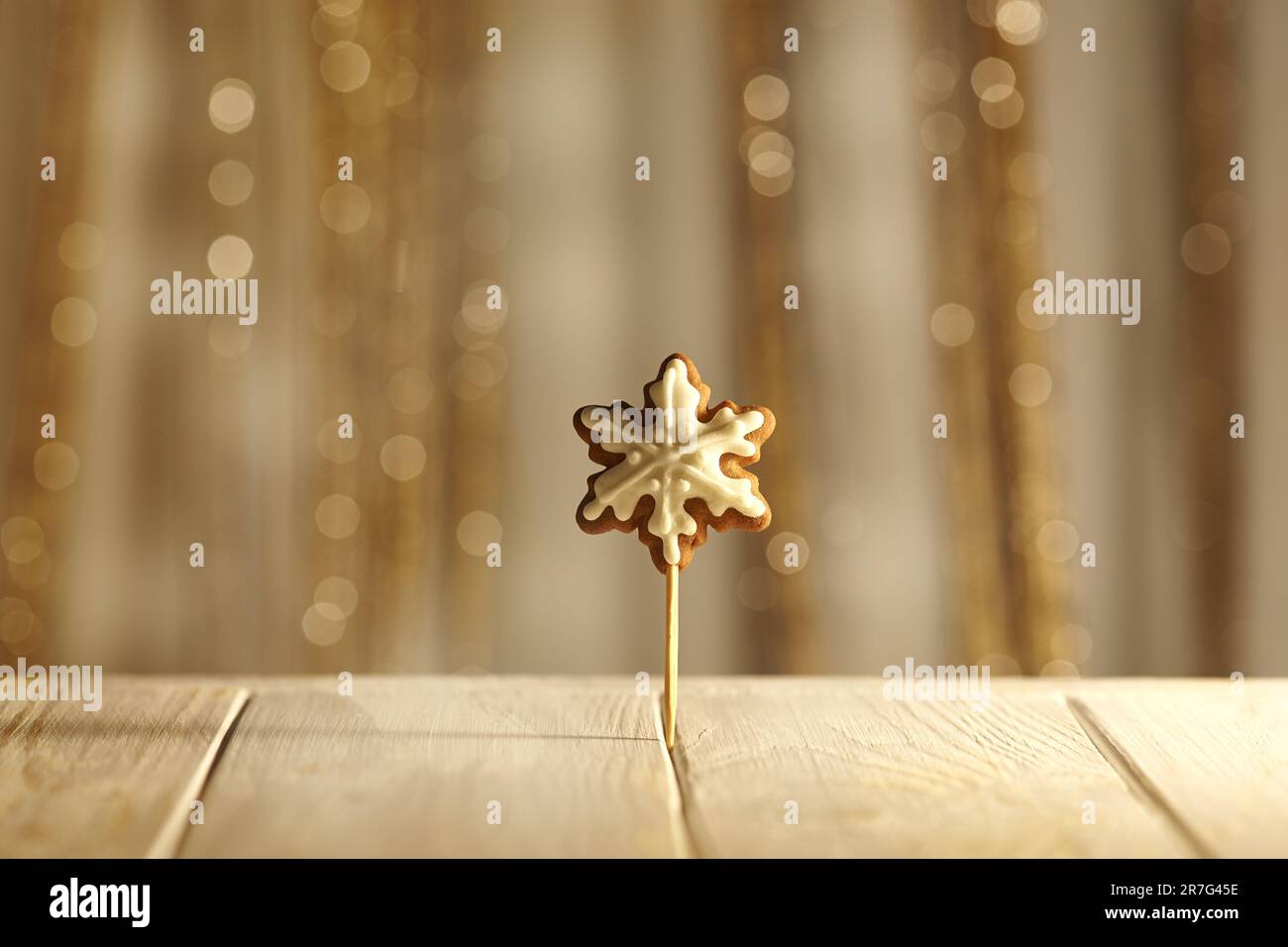 Weihnachtlicher Hintergrund in Pastelltönen. Minimales weihnachtskonzept, Schneeflocke Honig Lebkuchen. Weihnachten Schneeflocke. Selbstgemachtes Lebkuchen auf einem Stock. Stockfoto
