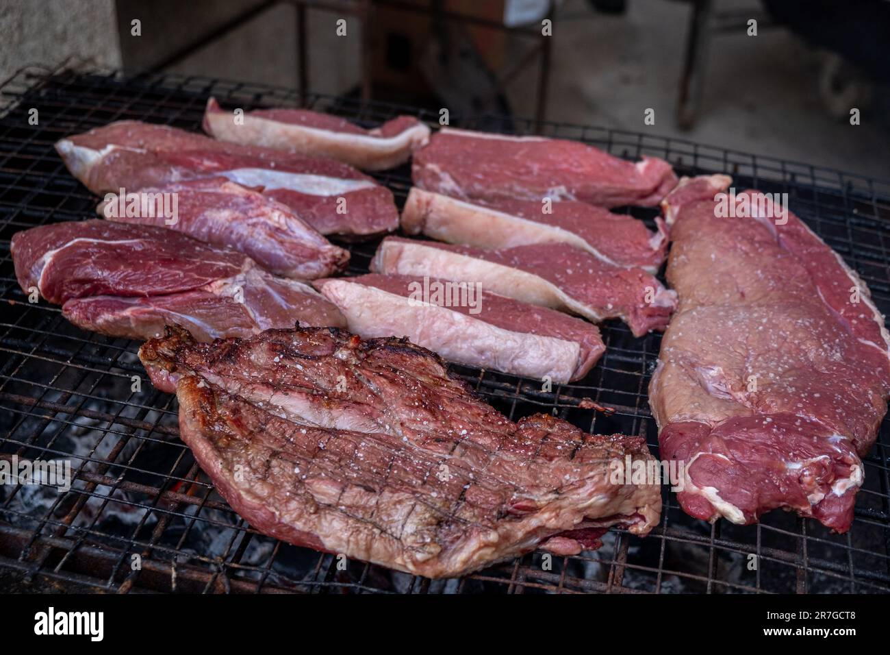 Bio-Rindfleischstücke, die auf einem Grill zubereitet werden Stockfoto