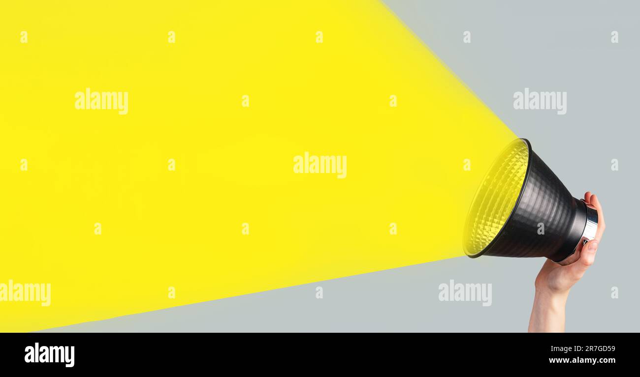 Bull Horn, Lautsprecher, Megafon mit gelbem Lichtstrahl in der Hand, Bannerhintergrund für Ankündigung, Werbung. Stockfoto