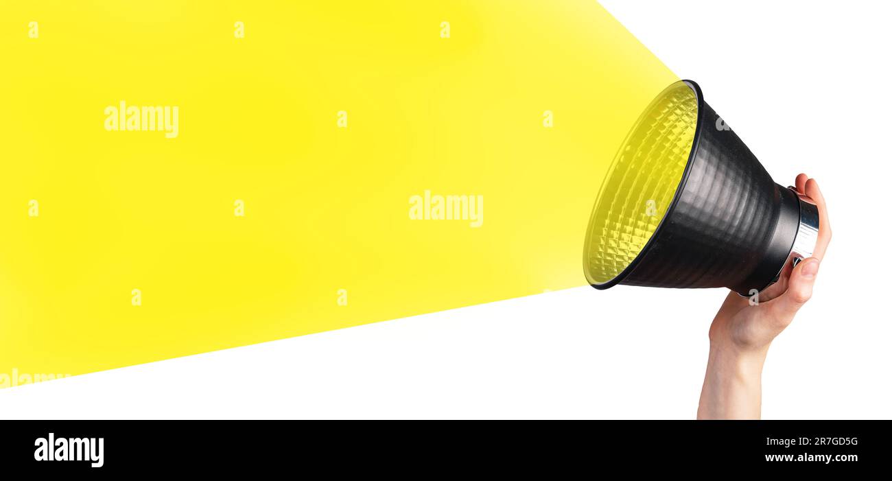 Hand hält Bull Horn, lauter Lautsprecher mit gelbem Lichtstrahl, Bannerhintergrund für Ankündigungen, Werbung. Stockfoto