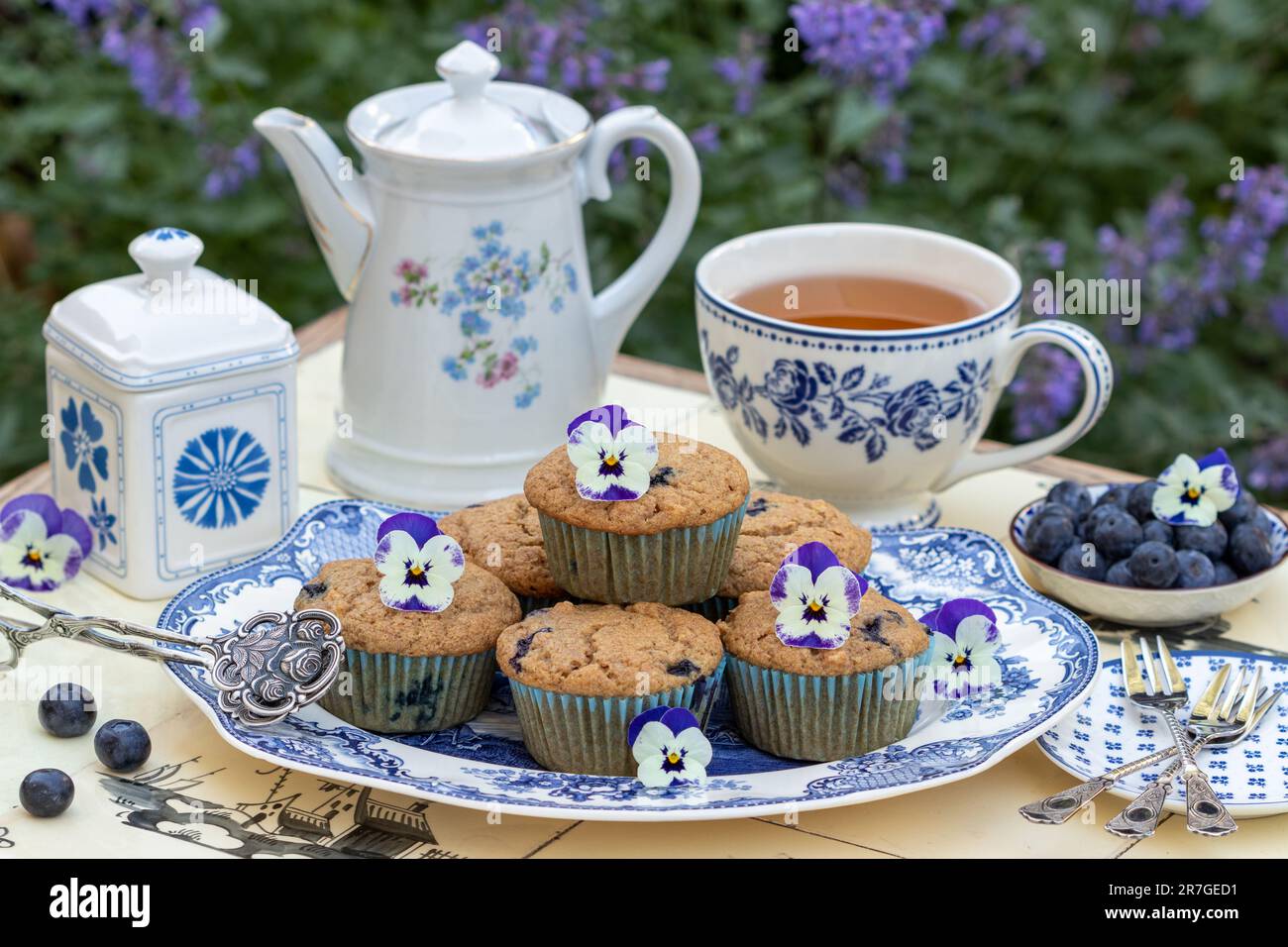 Vegane Apfel Blaubeeren Muffins auf dem Teller und weiße blaue Teegeschirr Stockfoto